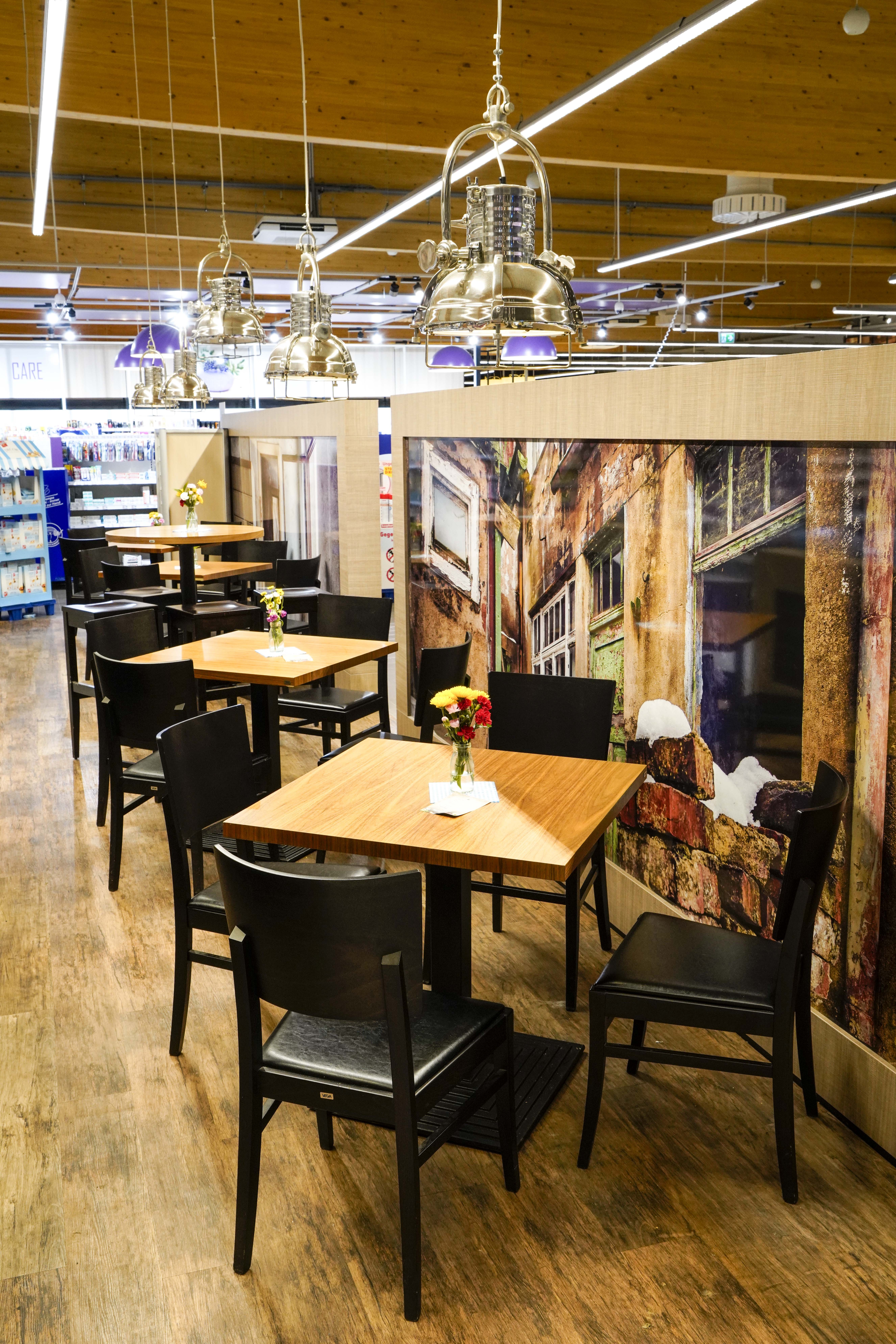 Tische und Stühle im Gastro-Bereich des EDEKA-Marktes.