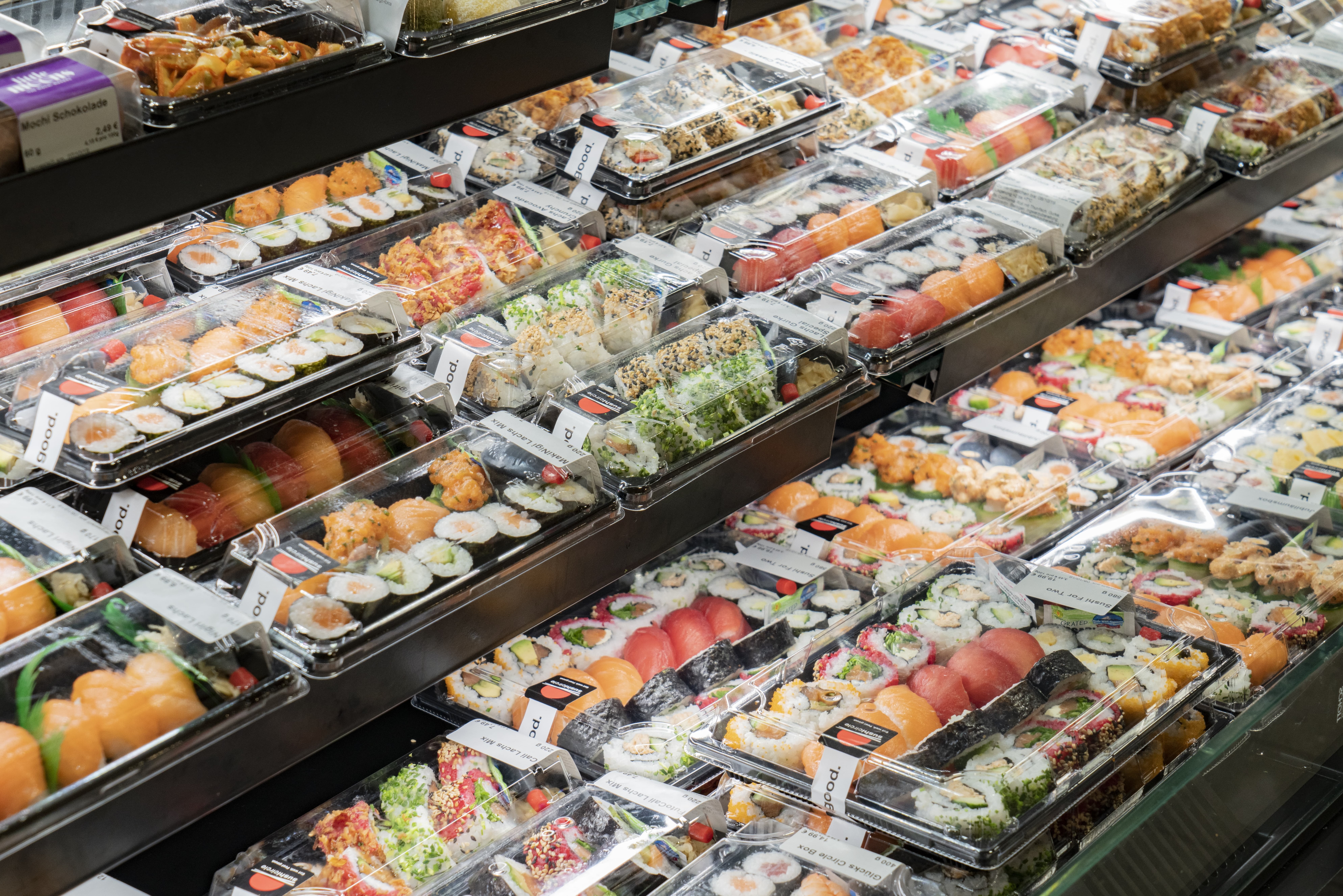 Sushi-Varianten in Einweg-Behältern aus Plastik.