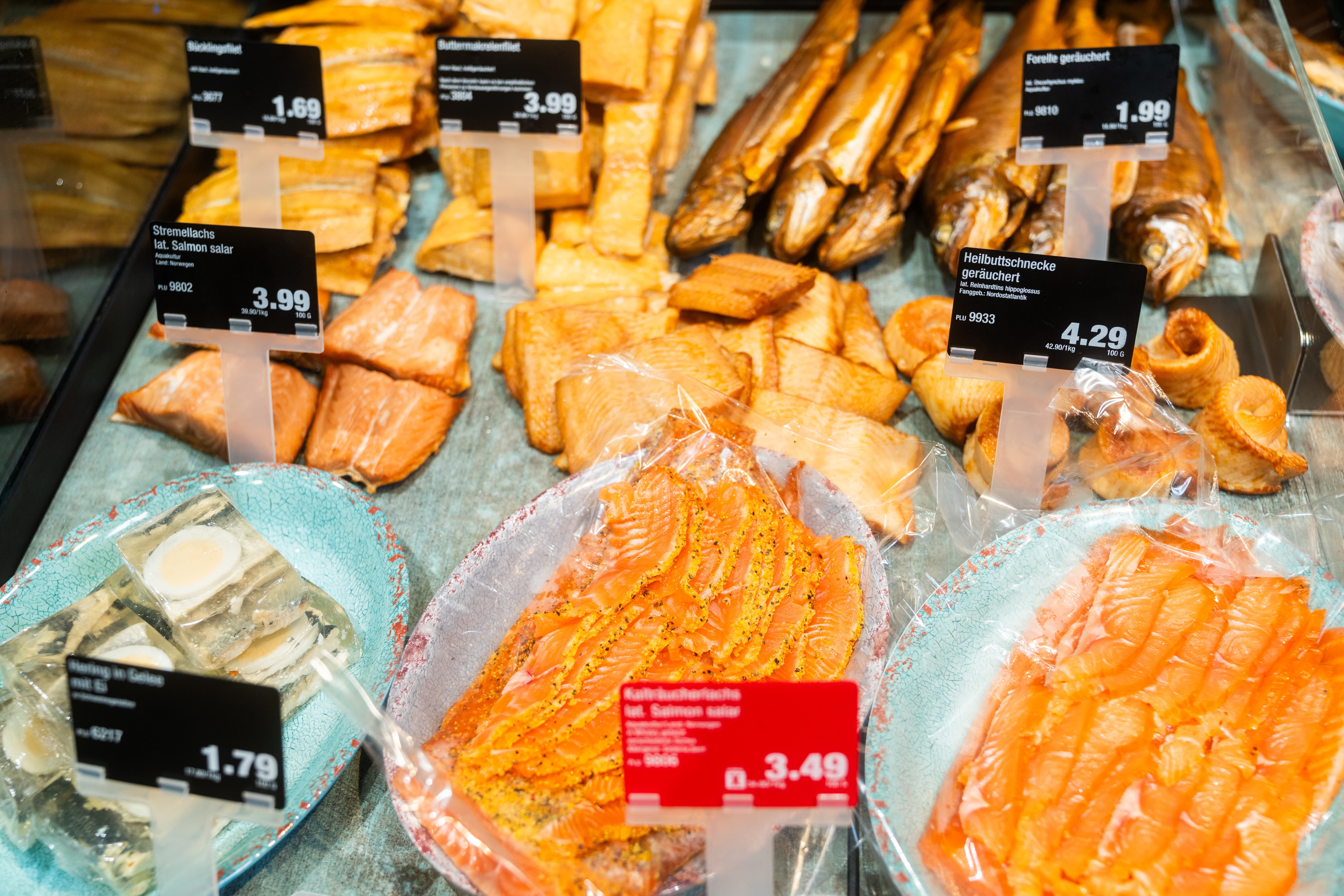 Räucherfisch in Scheiben und Stücken mit Preisschildern.