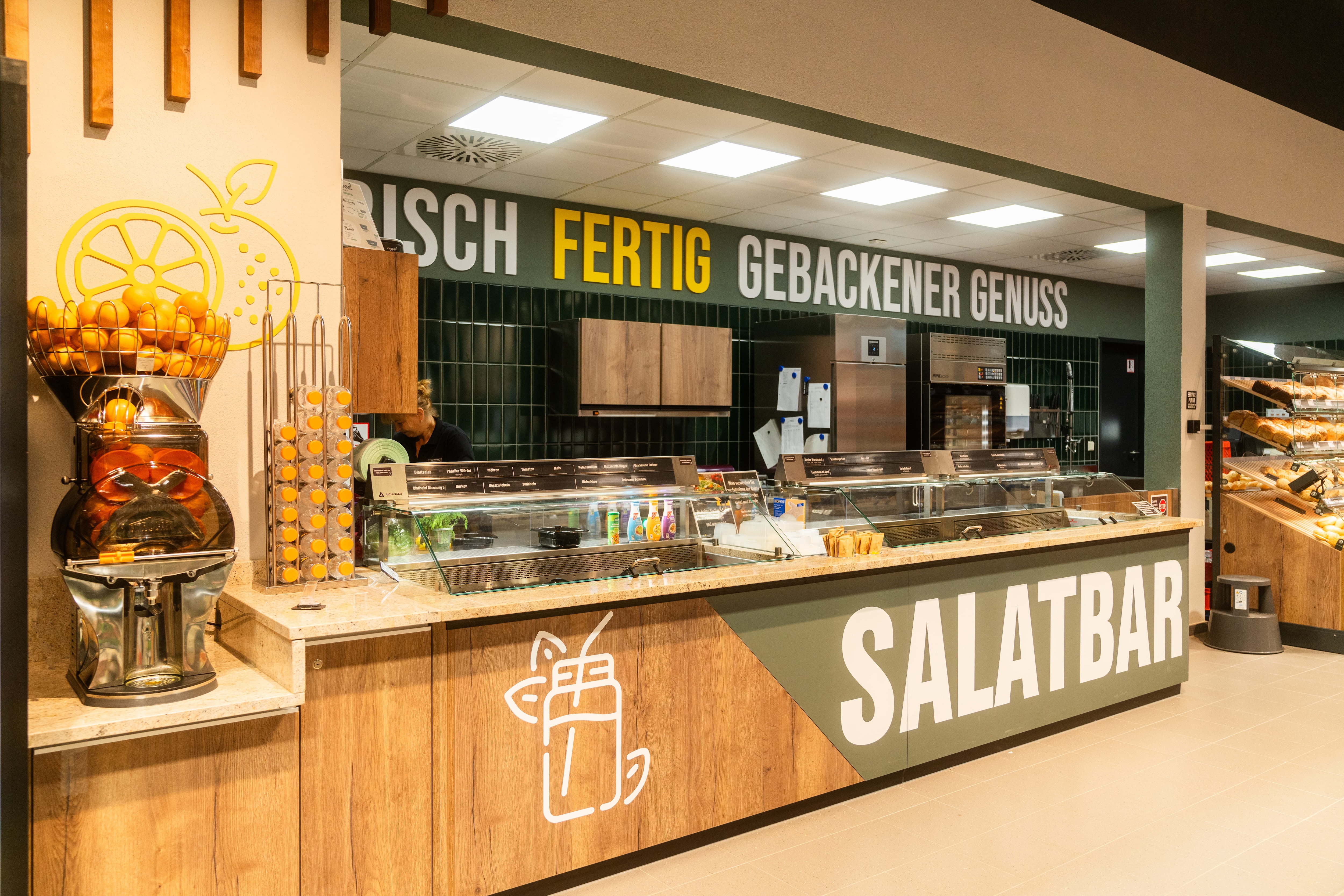Salatbar und Saftpresse für Orangen im EDEKA-Markt.