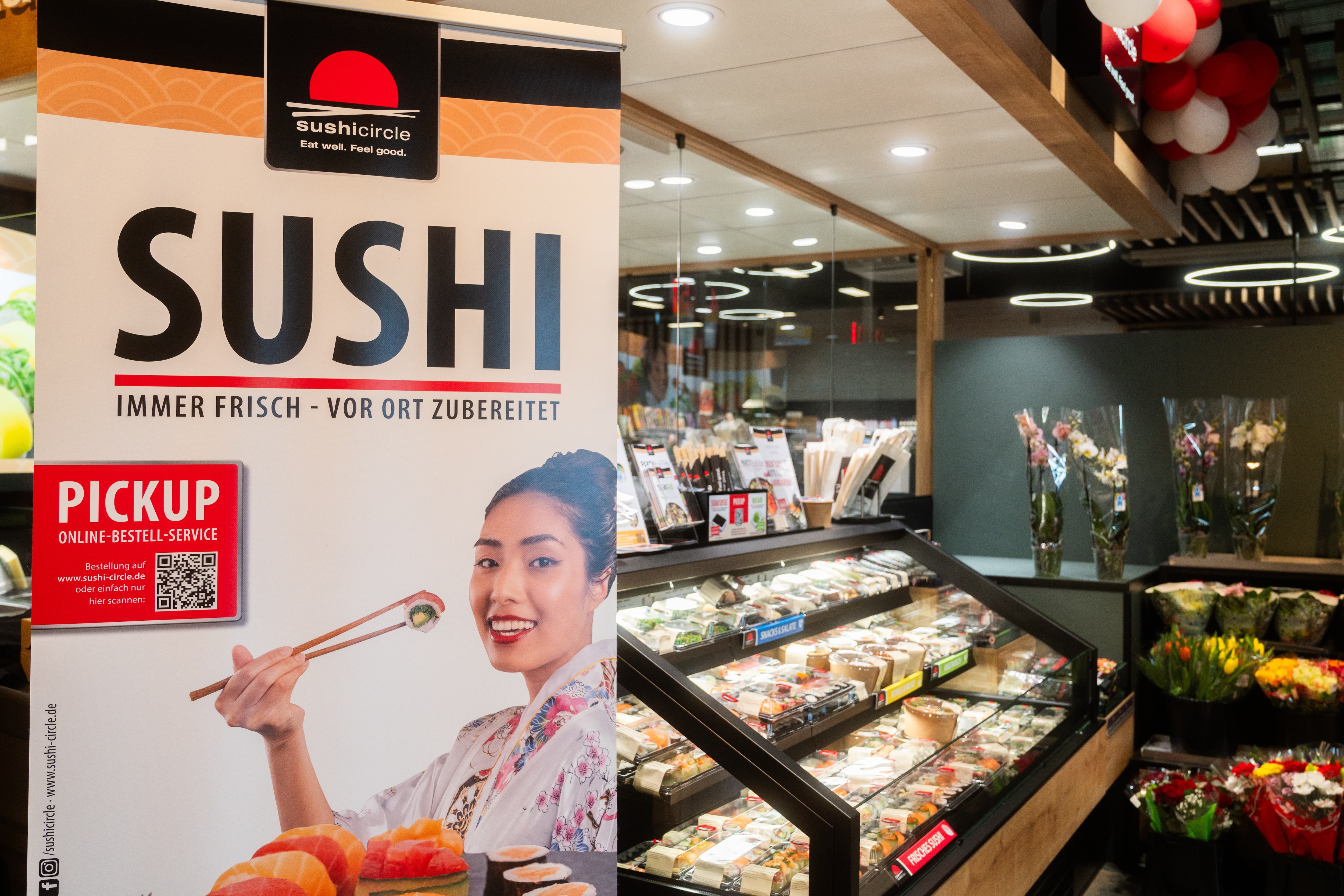 Auf einem Schild neben den Sushi-Packungen steht: Sushi. Immer frisch vor Ort zubereitet.