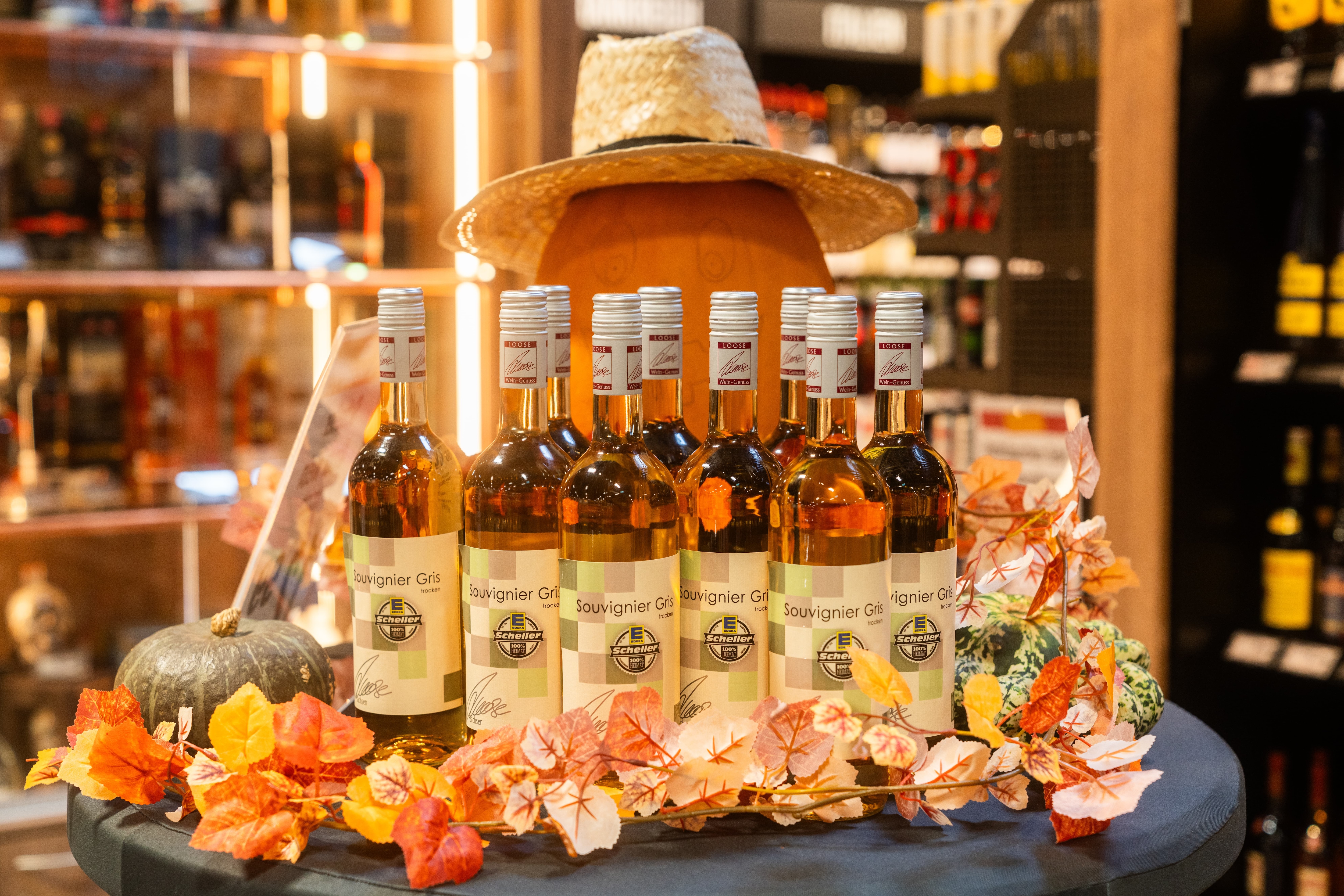 Kleiner runder Tisch mit Weißweinflaschen. Auf den Etiketten steht Souvignier Gris.