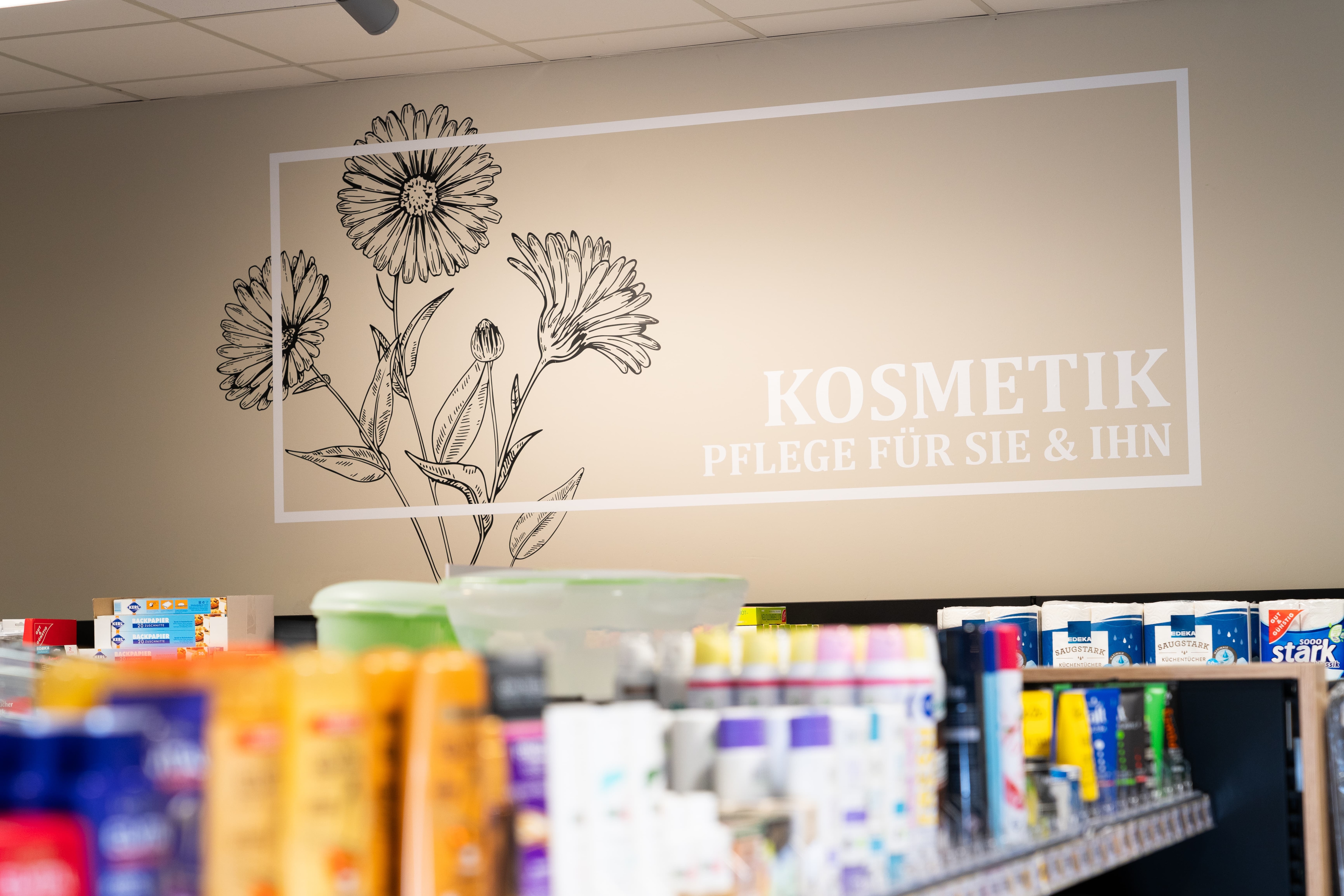 Über dem Regal für Pflegeprodukte steht Kosmetik, Pflege für sie und ihn.