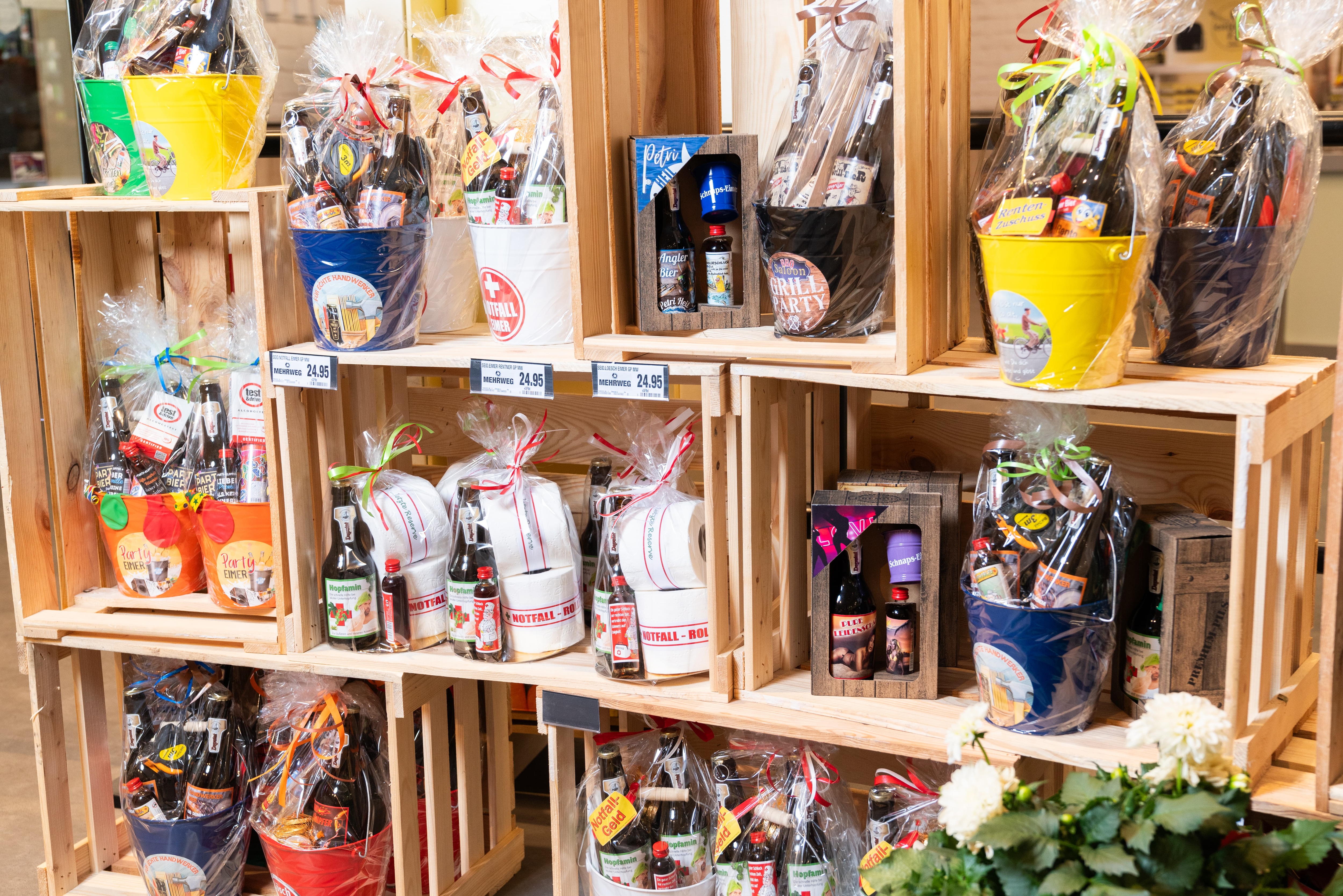 Kleine Präsentkörbe in einem Holzregal.