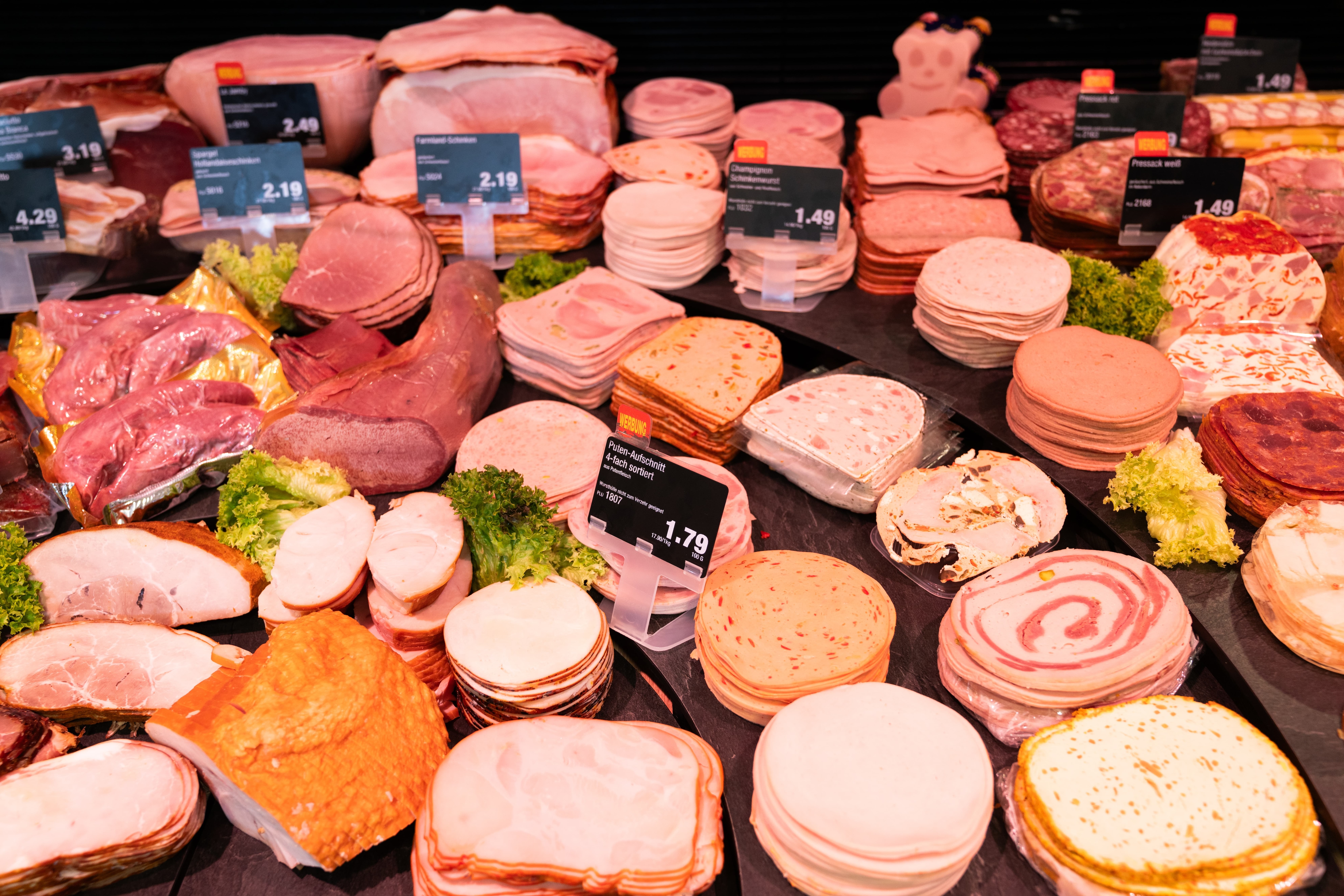 Wurst-Aufschnitt-Theke mit Preisschildern.