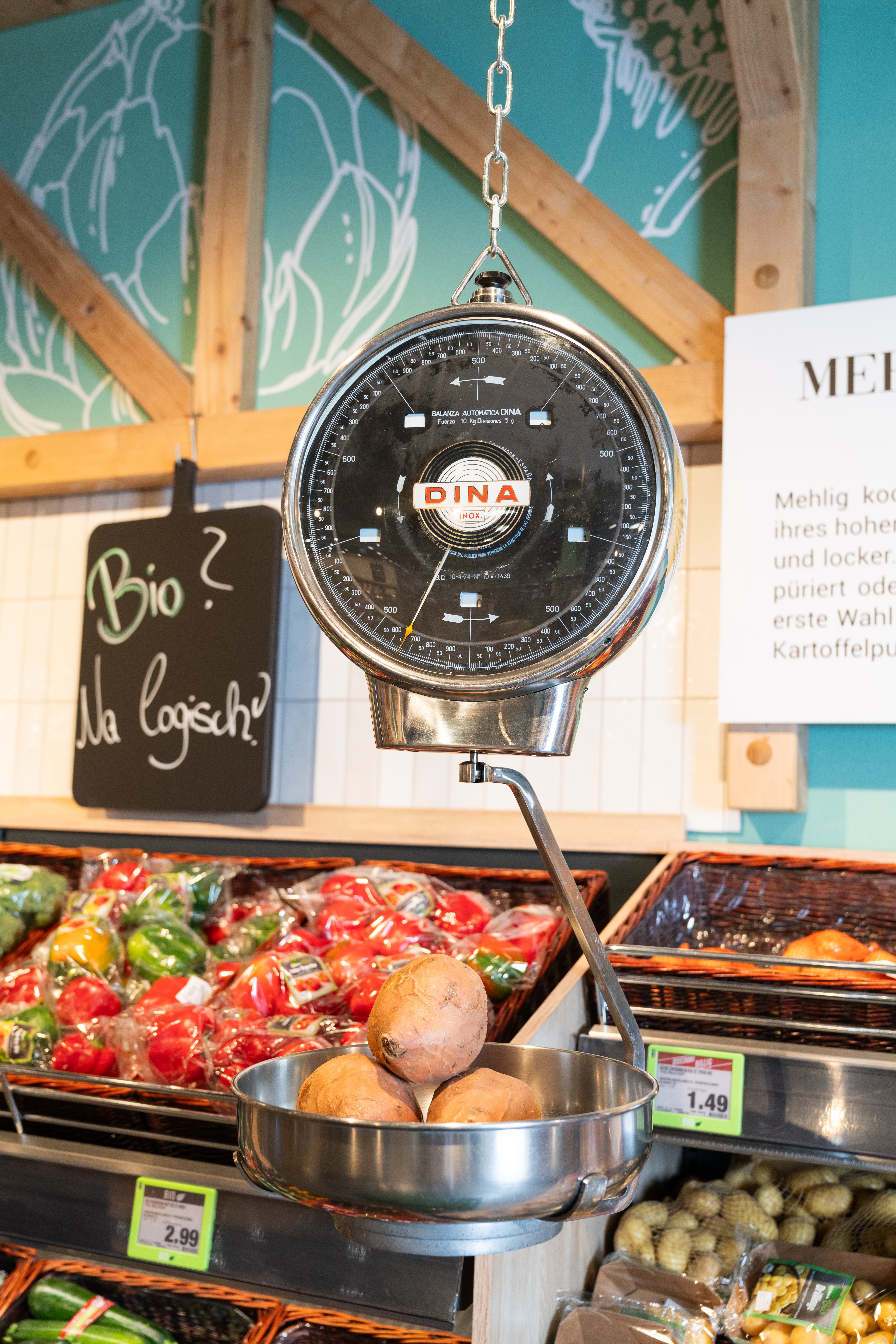 Im Schälchen einer analogen Hängewaage liegen drei Süßkartoffeln.