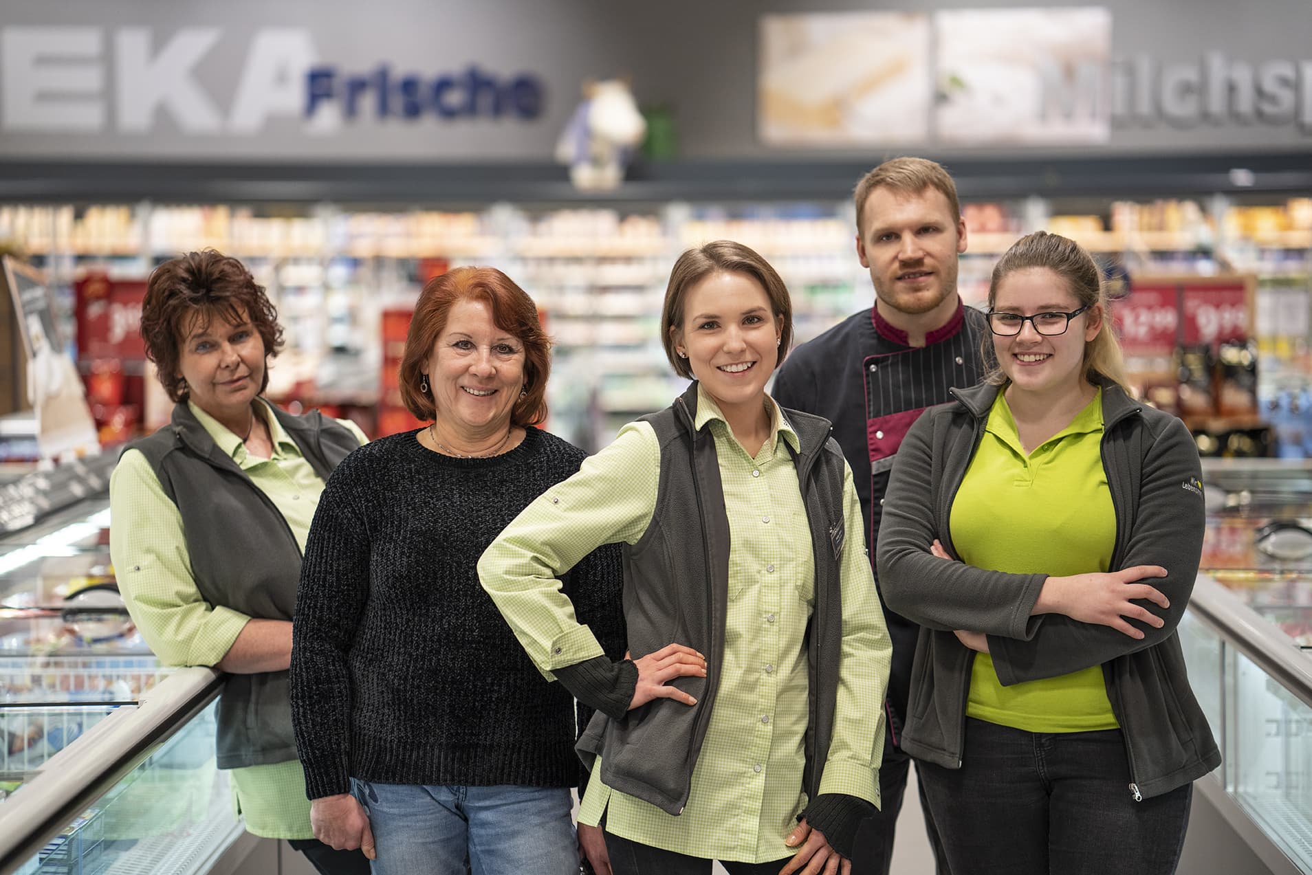 Gruppenfoto des Teams dieses EDEKA-Markts, aufgenommen im Gang im Tiefkühlbereich.