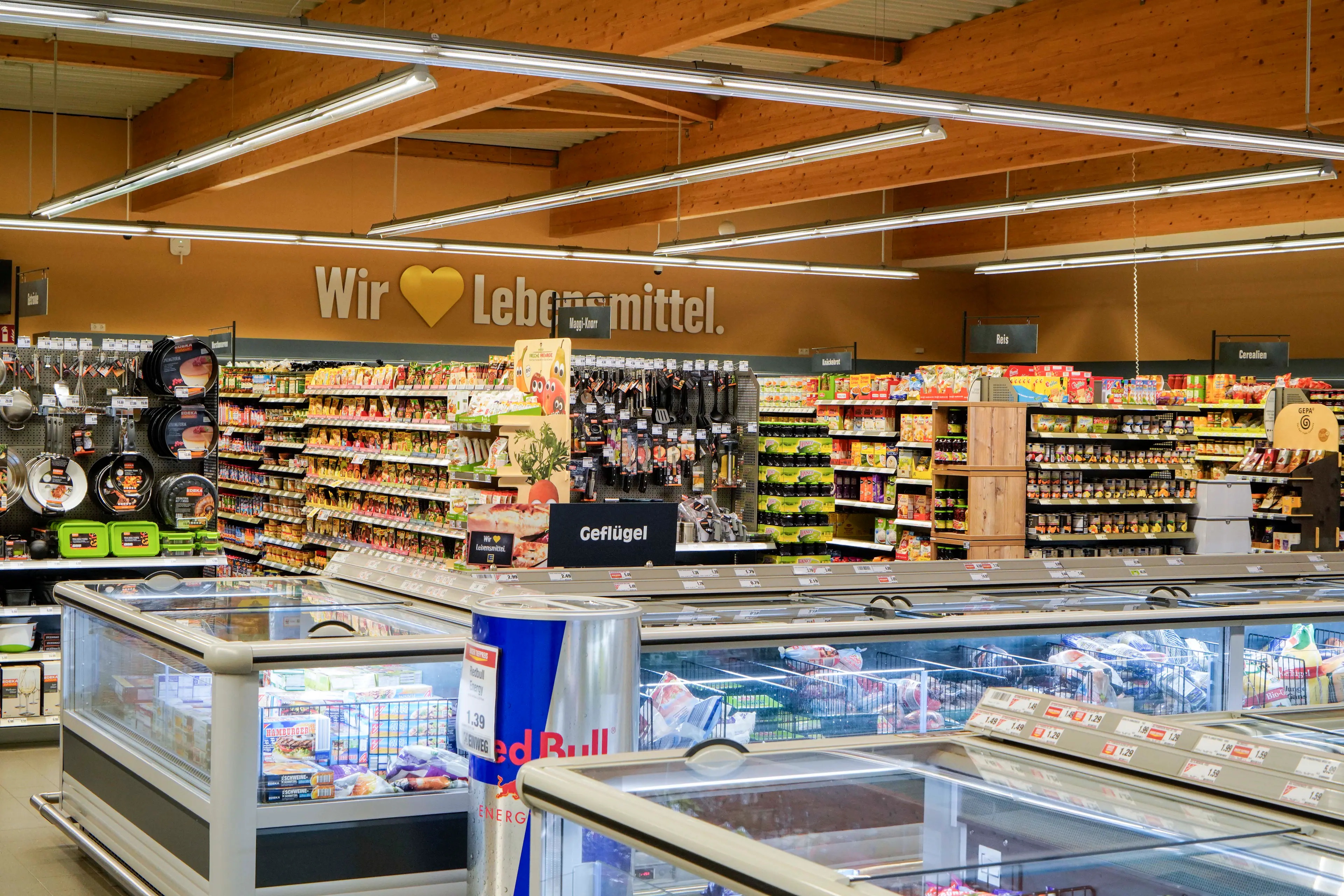Blick über die Kühltruhen auf die Regalreihen eines EDEKA-Marktes.