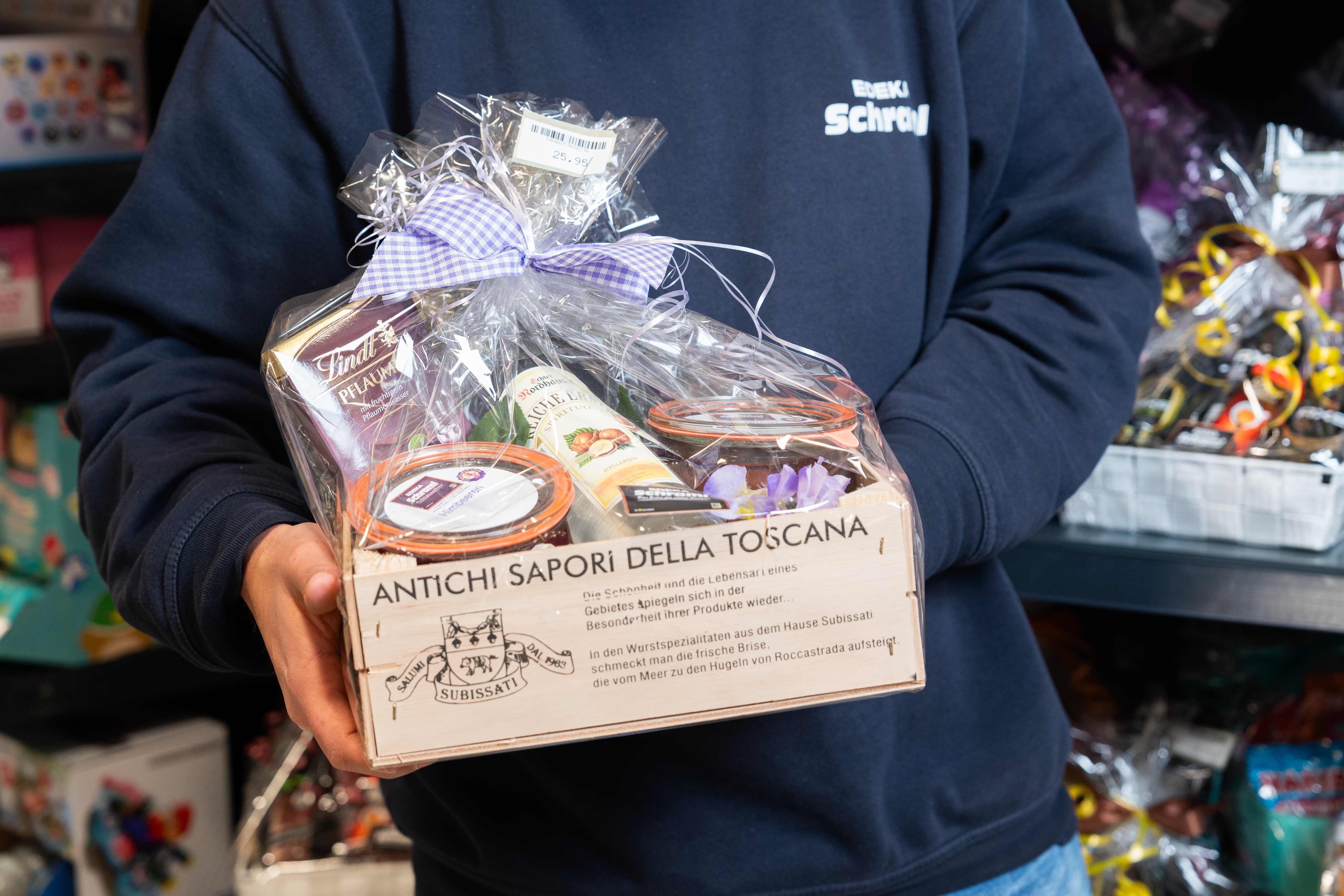 Ein Mitarbeiter hält einen Präsentkorb in den Händen.