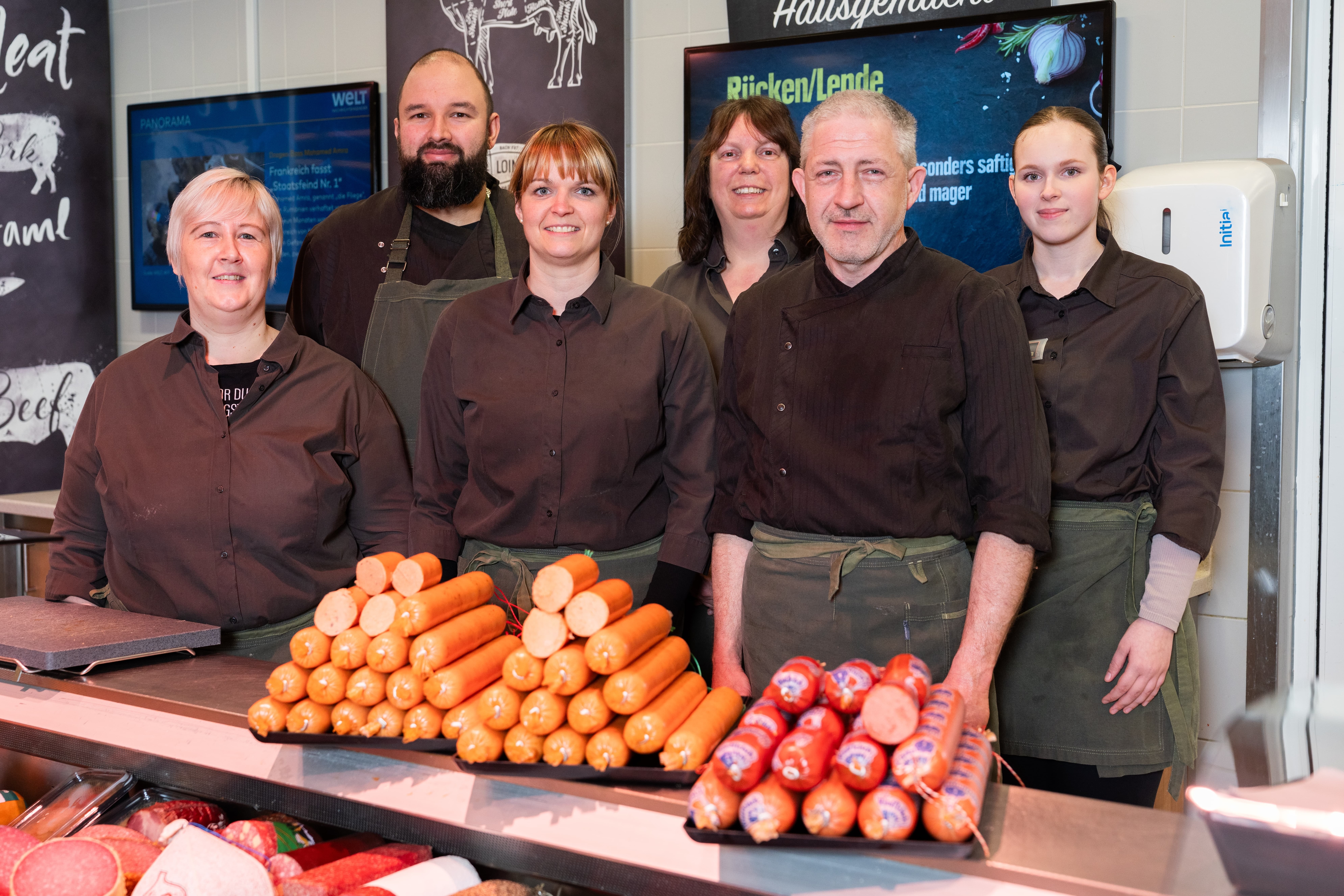 Gruppenfoto der Mitarbeitenden der Bedientheke hinter ihrem Tresen.