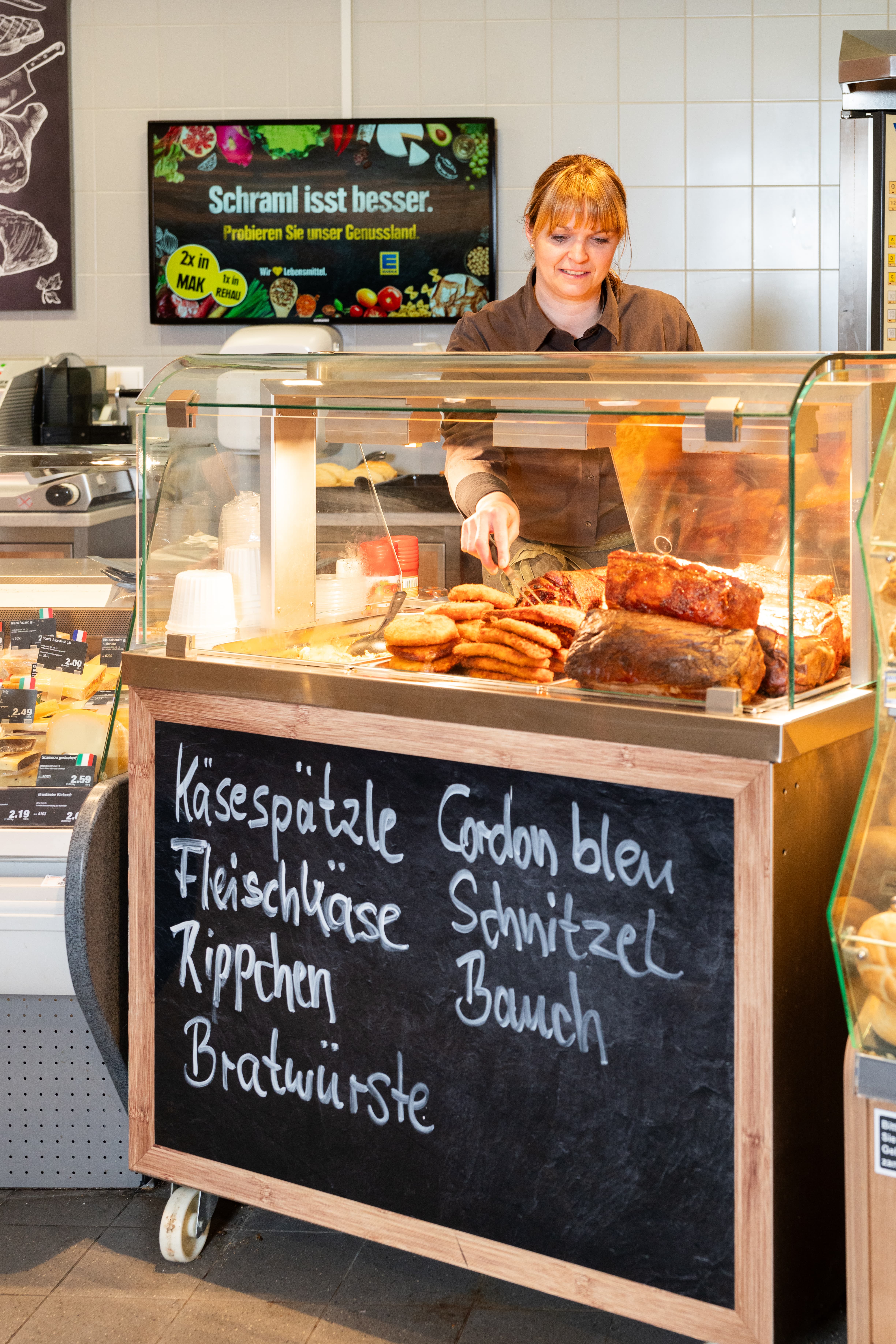 Eine Mitarbeiterin nimmt etwas aus der heißen Theke.