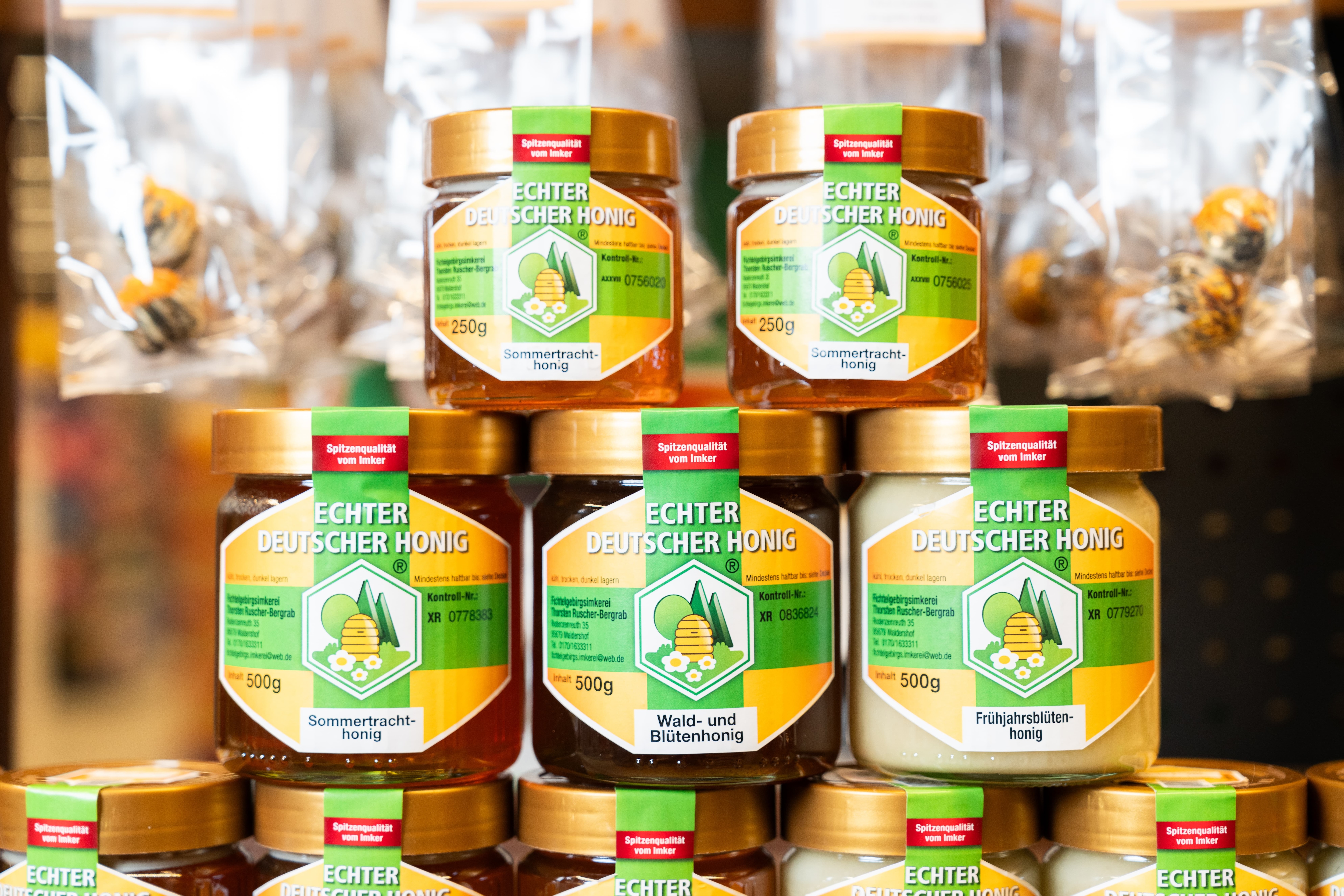 Einige Gläser Honig von der Fichtelgebirgsimkerei Bergrab sind in einer Pyramide angeordnet.