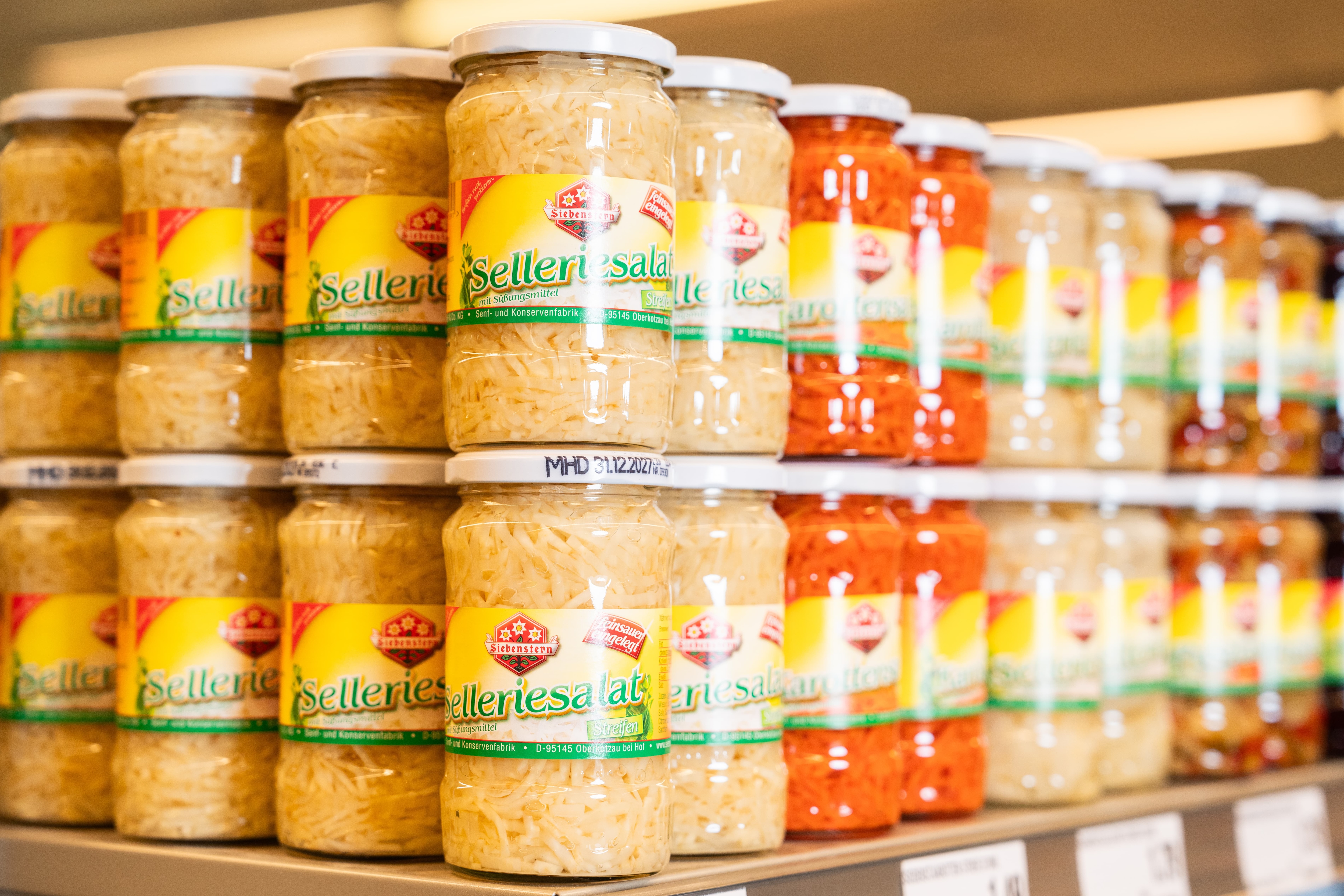 Gläser mit Sellerie- und Karottensalat von Siebenstern stehen im obersten Regalfach und sind von der Ecke her fotografiert.
