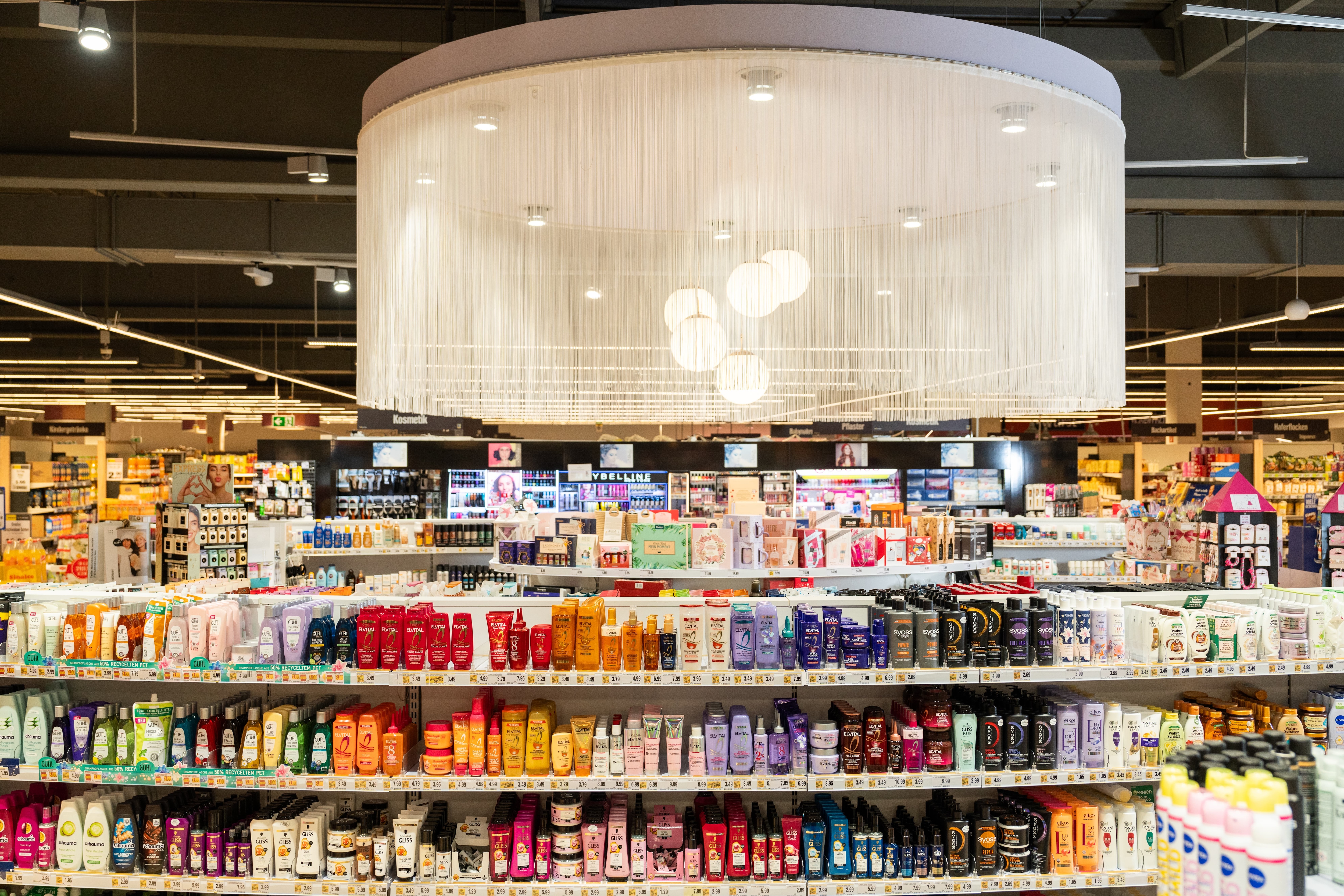 Ein Blich über die Regalreihen der Kosmetikabteilung eines EDEKA-Marktes.