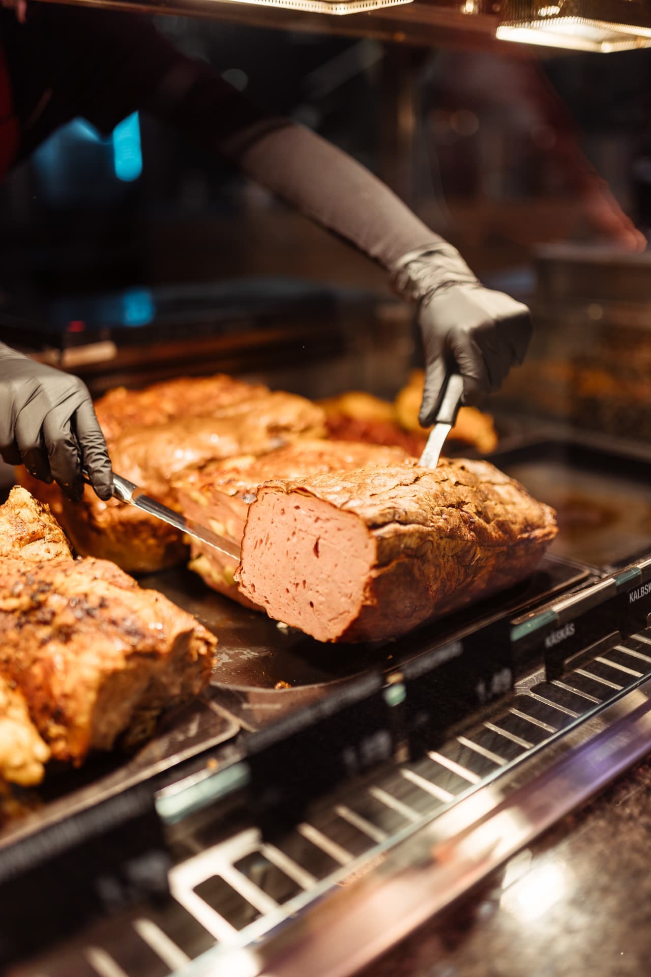 Ein Leberkäse in der Auslage einer Theke.