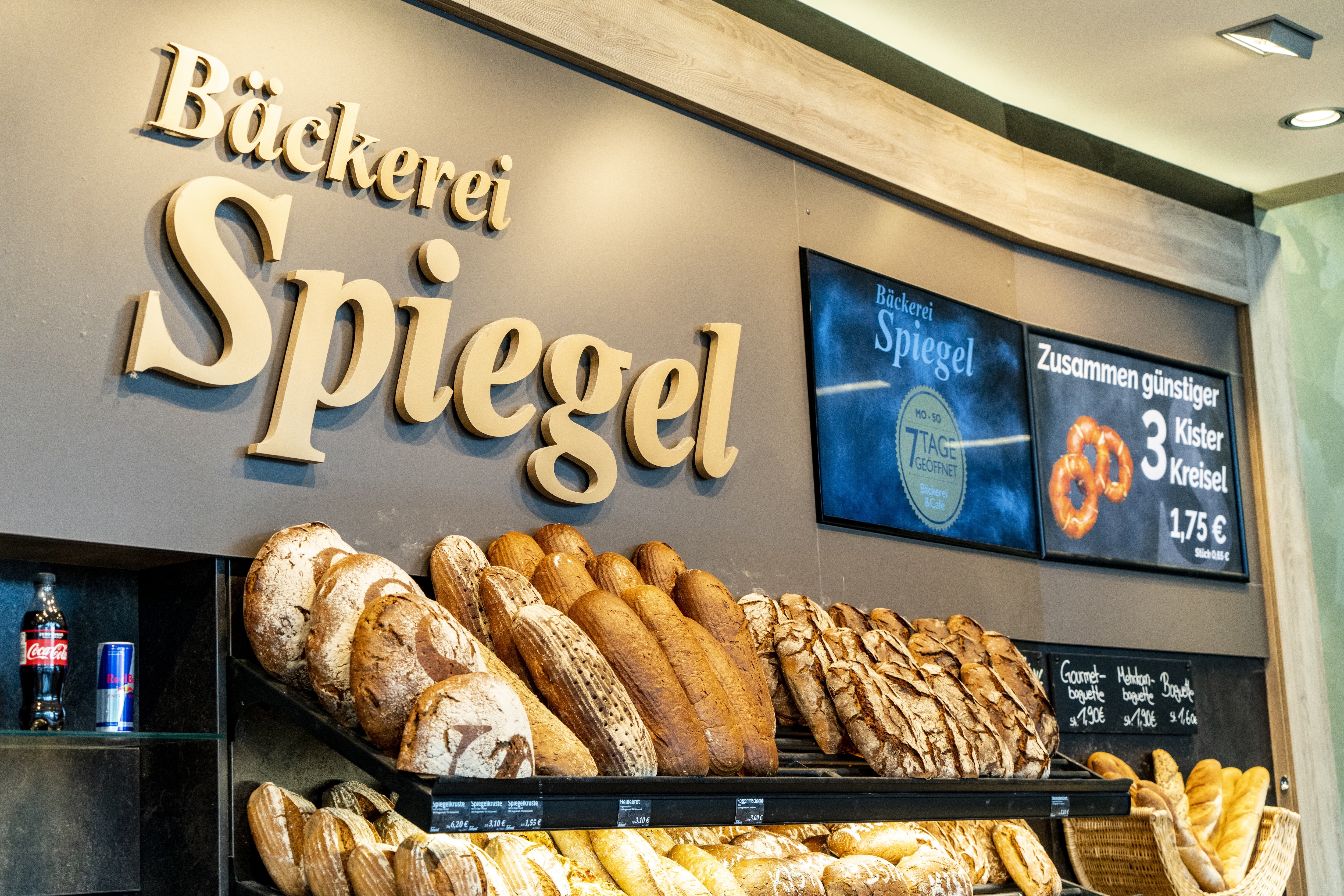 Die Bäckerei in diesem EDEKA-Markt, betitelt mit „Bäckerei Spiegel“ und verschiedenen Backwaren, belegt und unbelegt, in der Auslage.