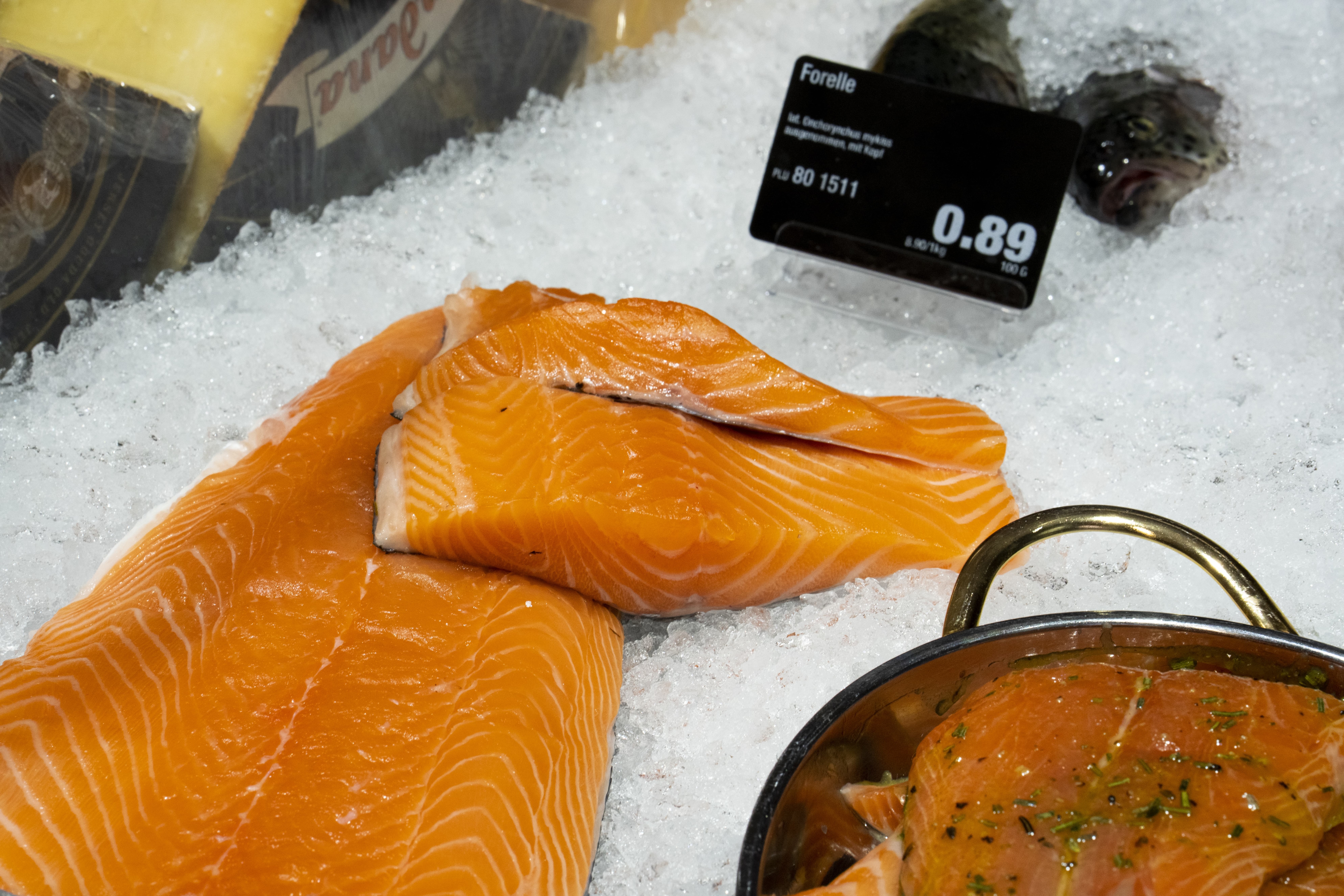 Fisch in einer Auslage im Close-Up, mit Preisschildern und Eis.
