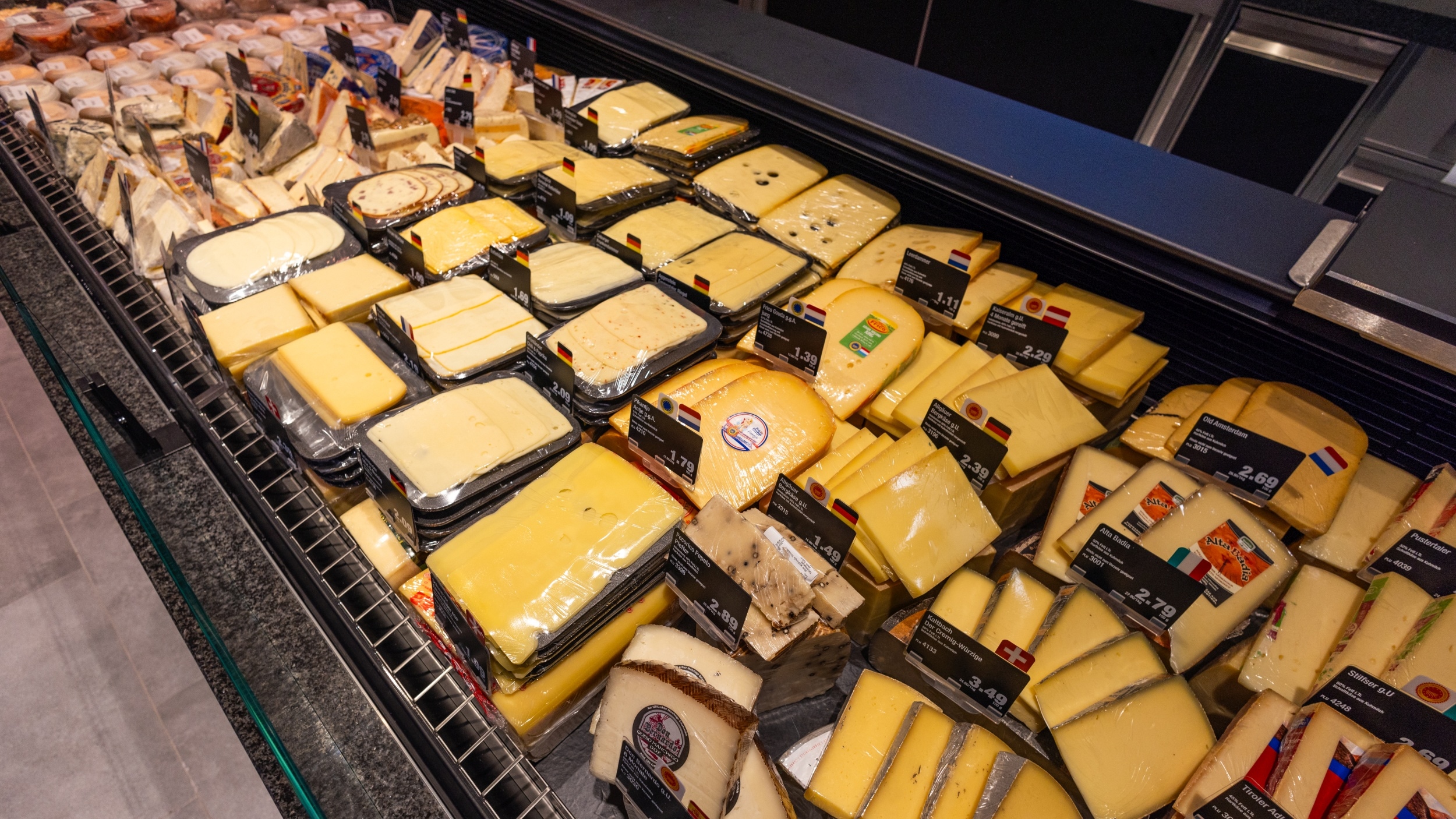 Verschiedene Scheiben- und Block-Käse-Sorten angeboten im Bereich der Frische-Käse-Theke