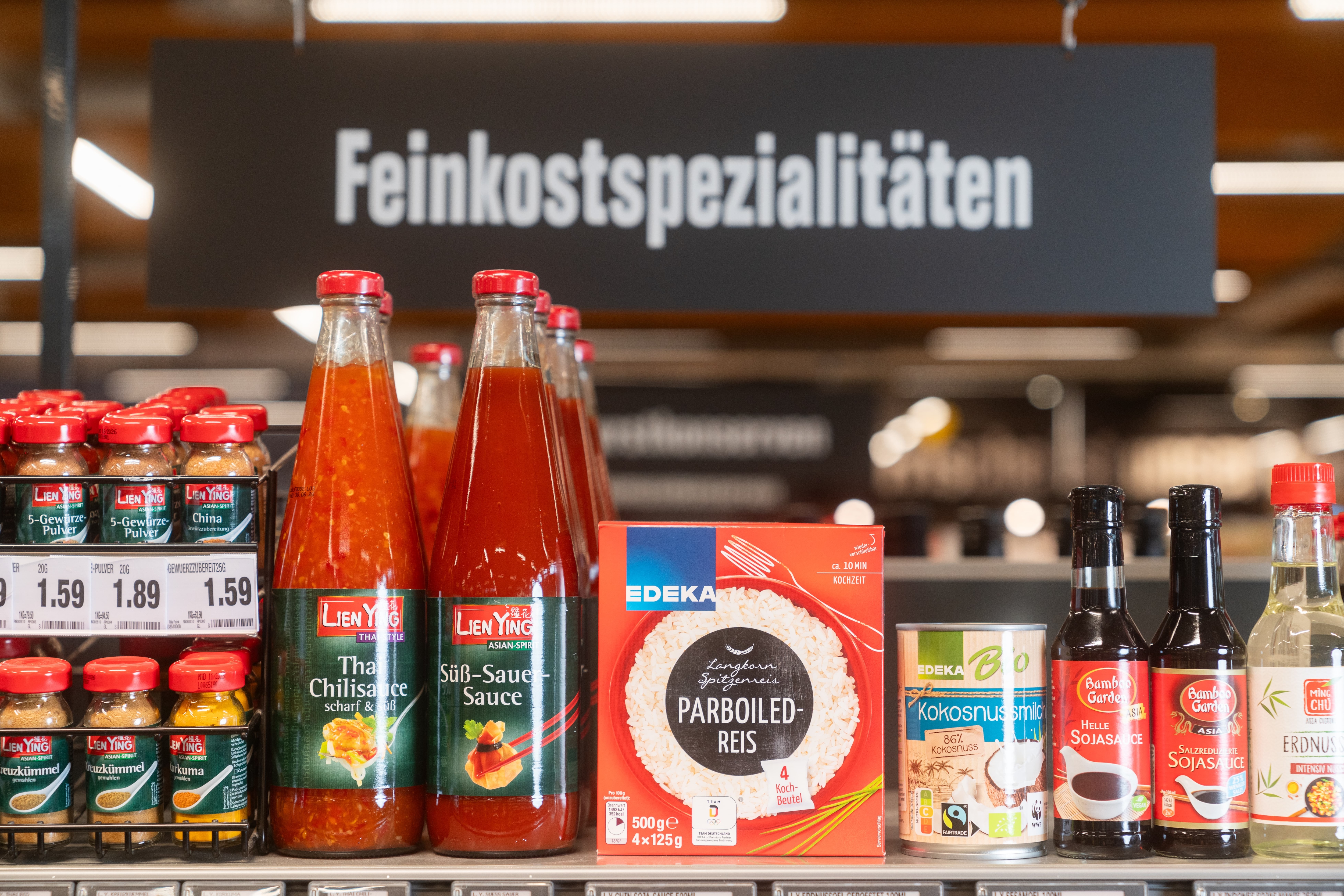 Ein Regal mit Gewürzen und Saucen der Marke Lien Ying sowie Reis Kokosnussmilch und Sojasauce.