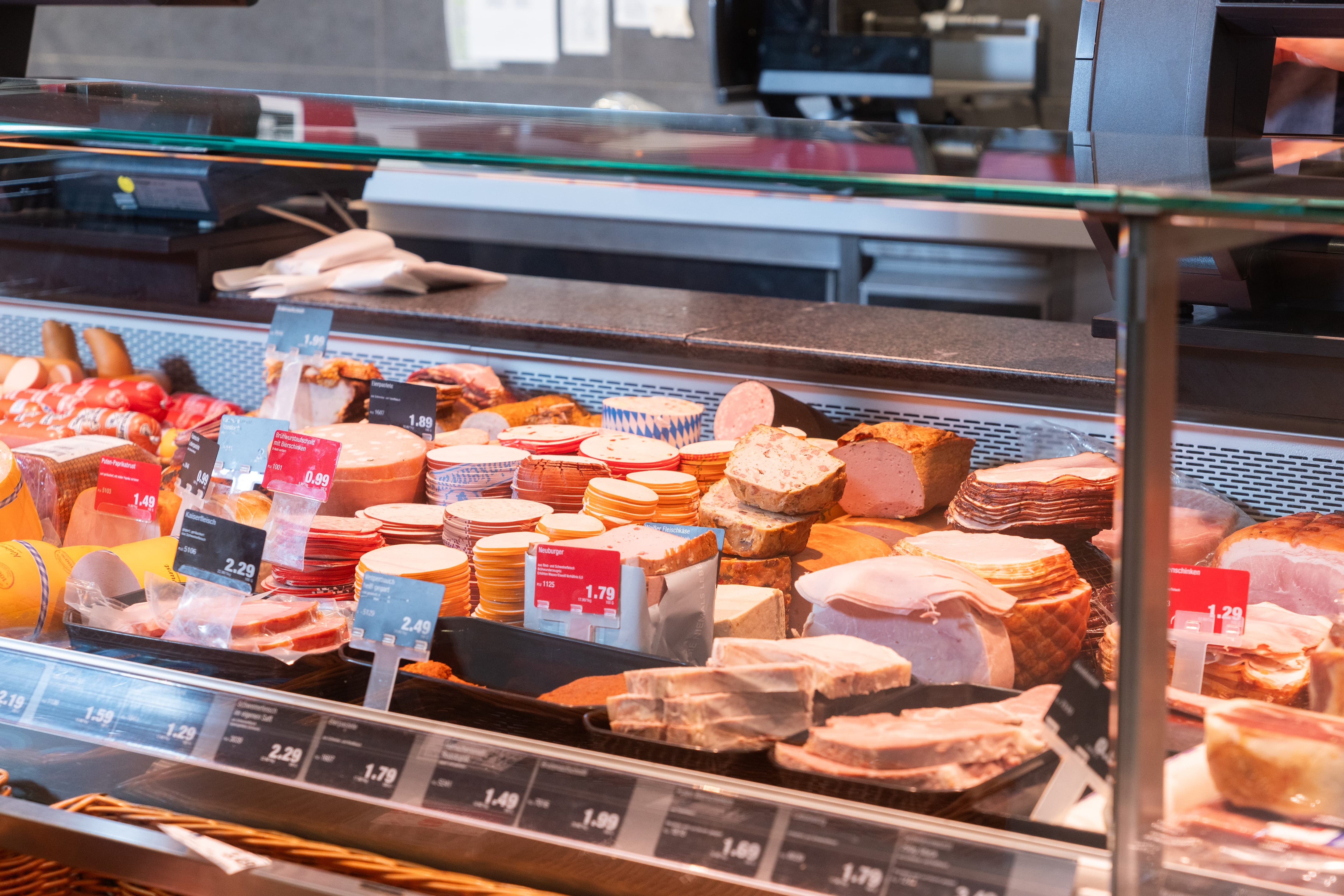 Wurst-Aufschnitt-Theke mit Preisschildern.