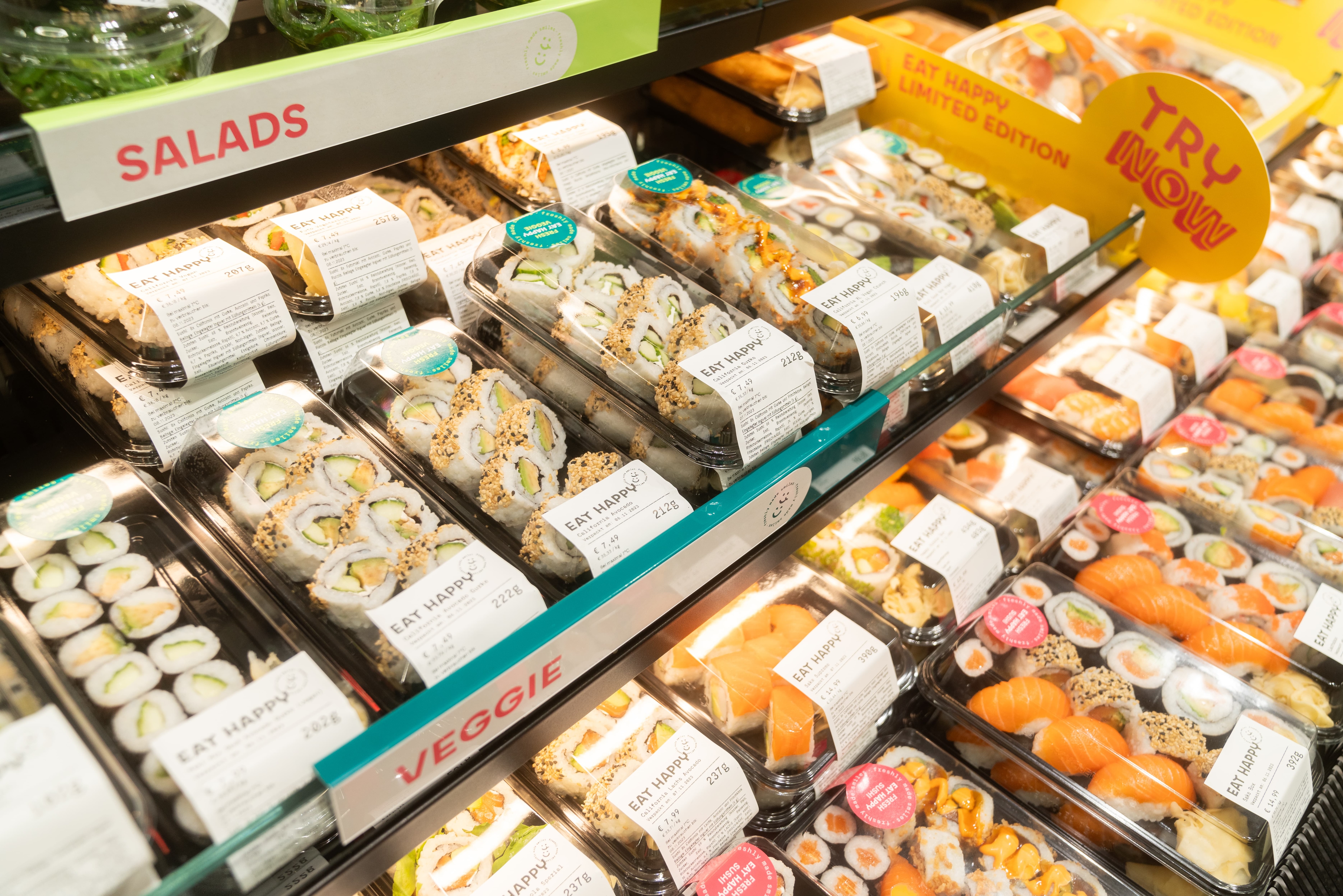 Transparente Plastikbehälter mit Sushirollen.