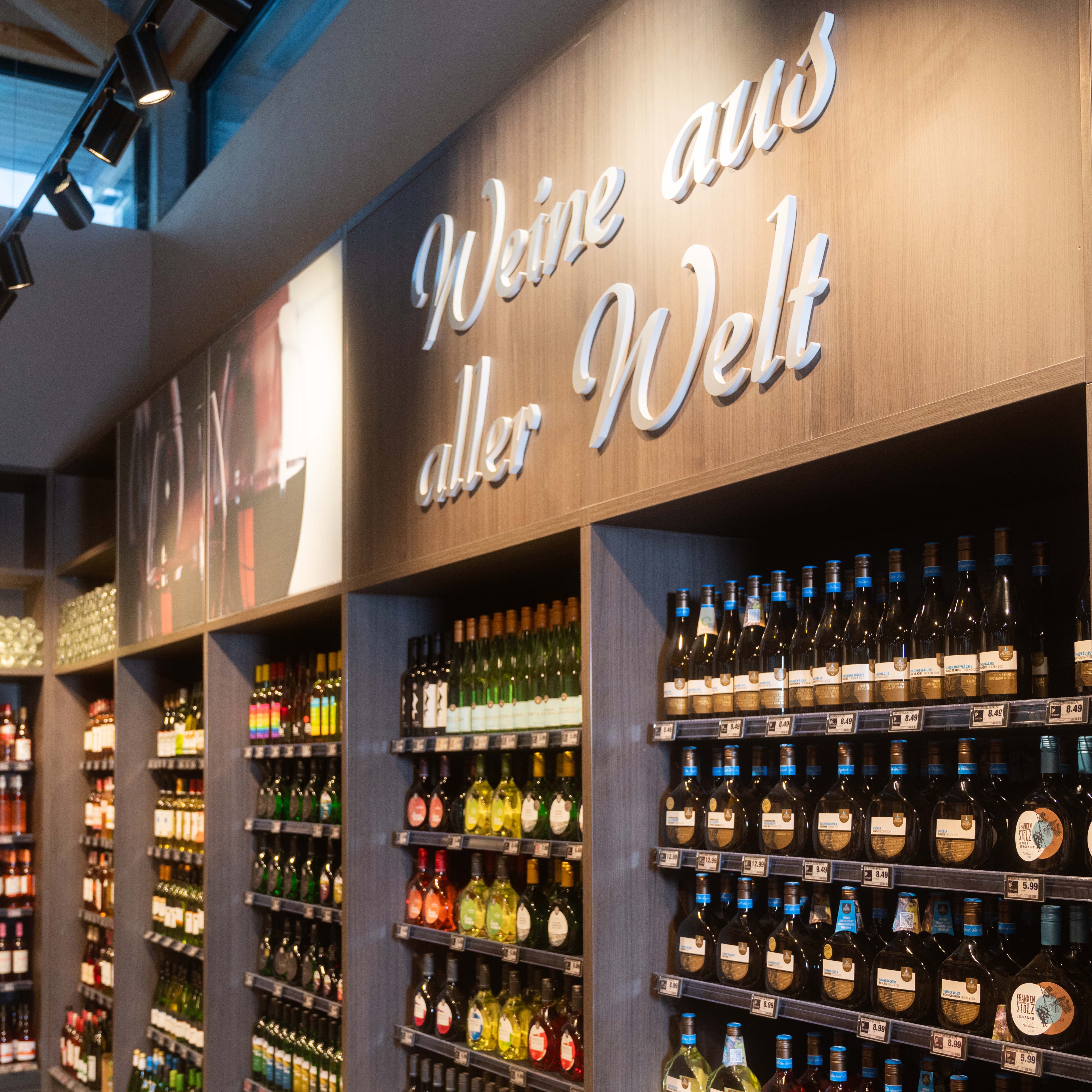 Über einem Regal in der Weinabteilung steht geschrieben: Weine aus aller Welt.