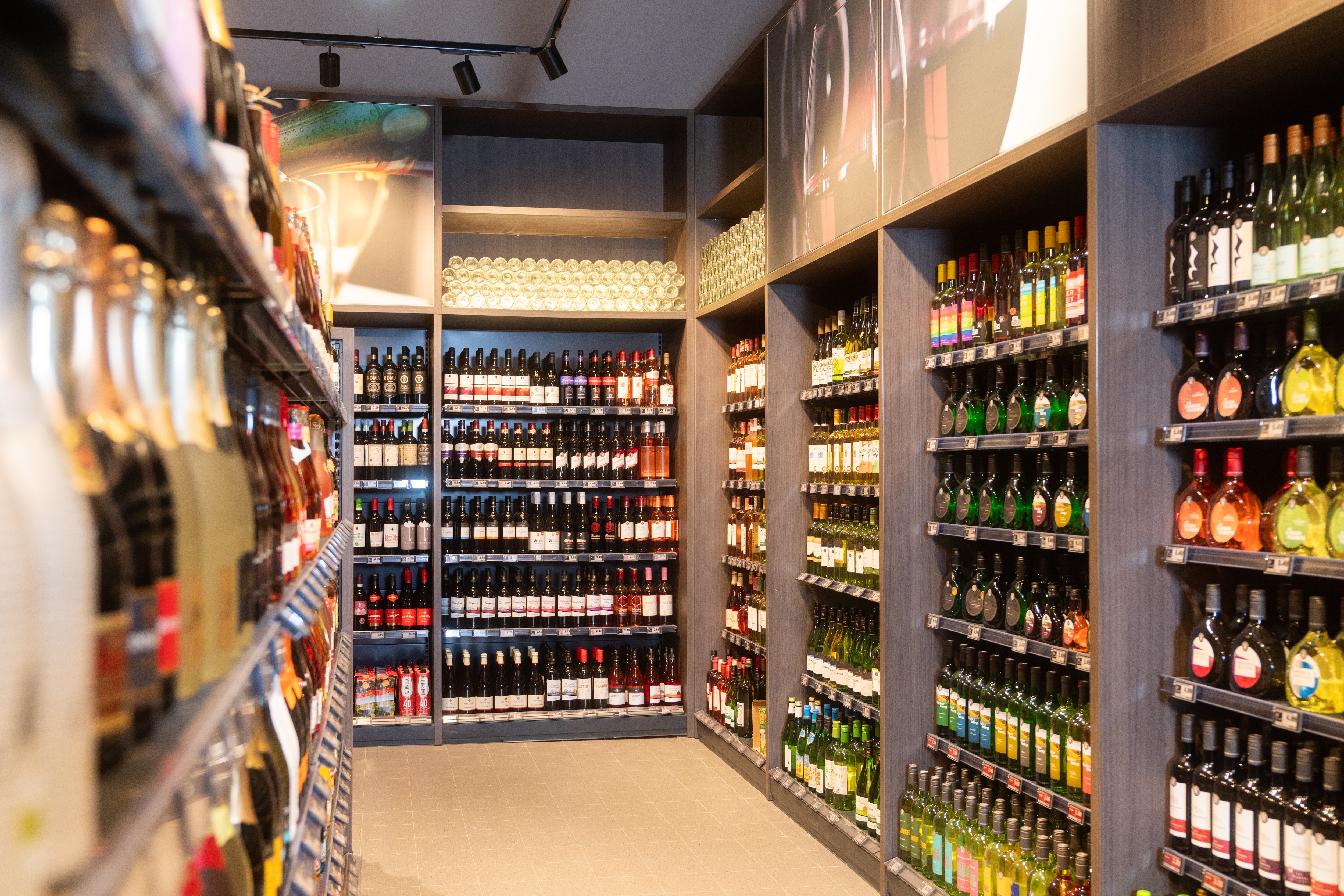 Regale mit Weinflaschen in verschiedenen Formen und Farben.