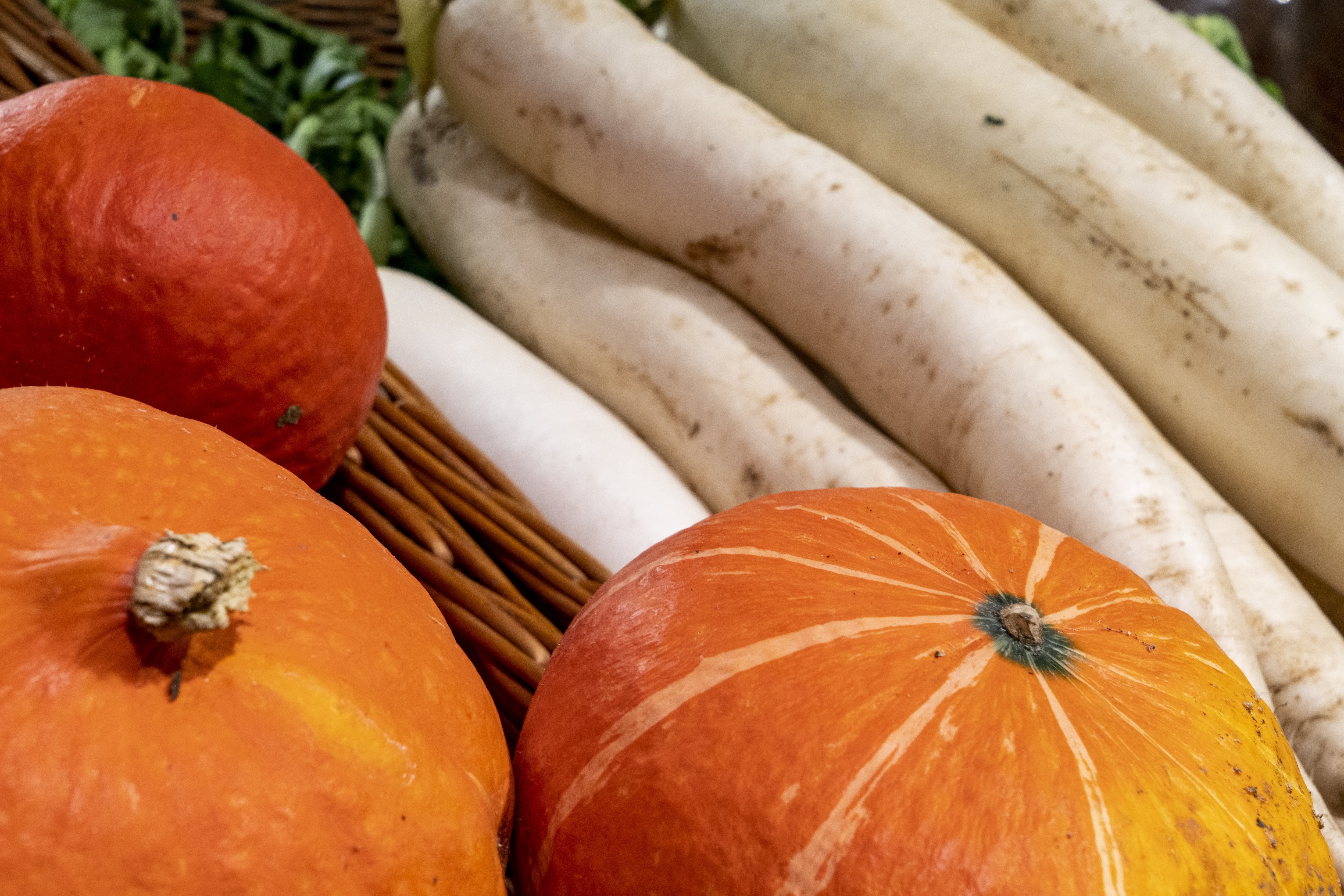 Close-Up von Gemüse, im Vordergrund drei große Kürbisse.