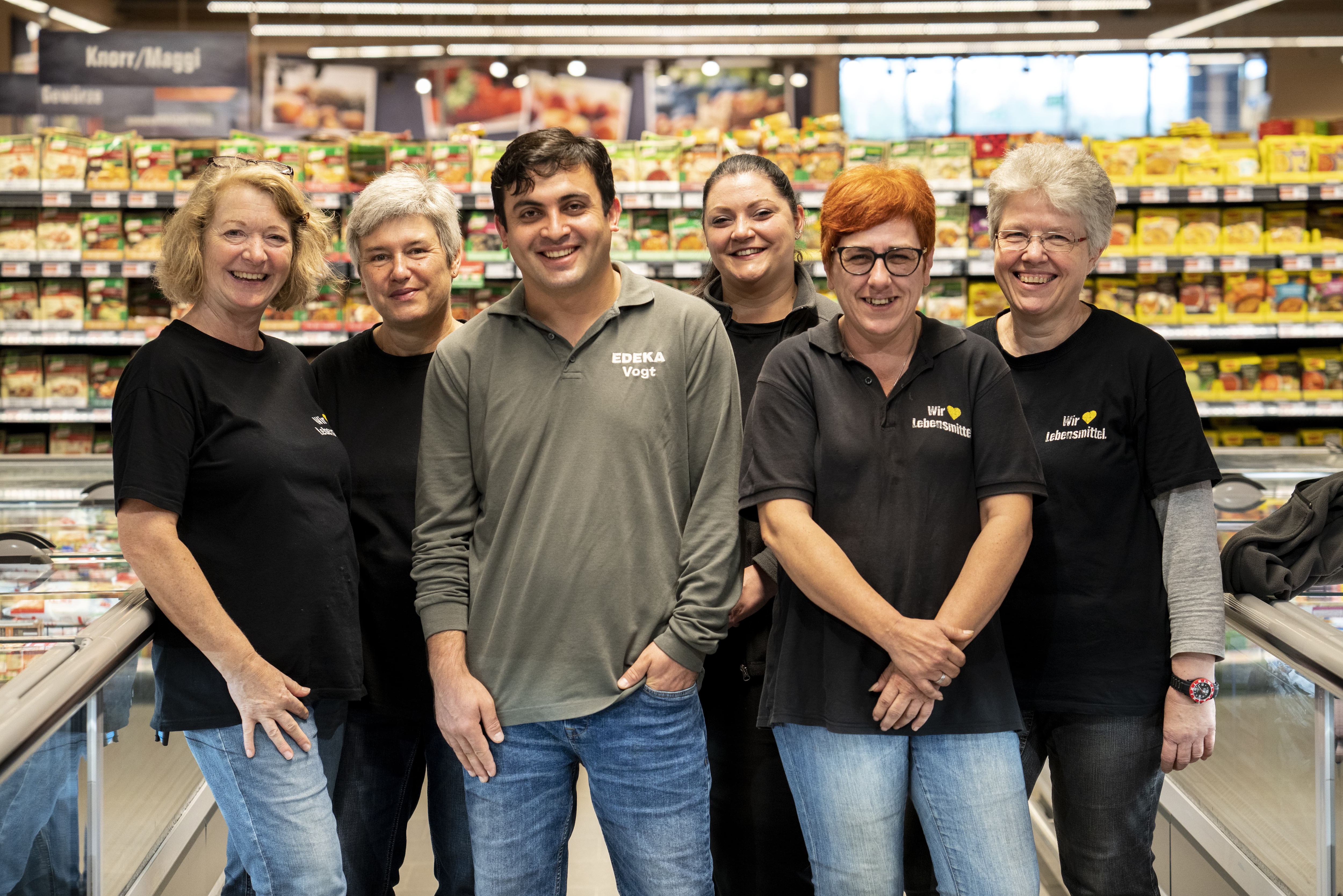 Gruppenfoto des Teams dieses EDEKA-Markts, aufgenommen im Gang im Tiefkühlbereich.