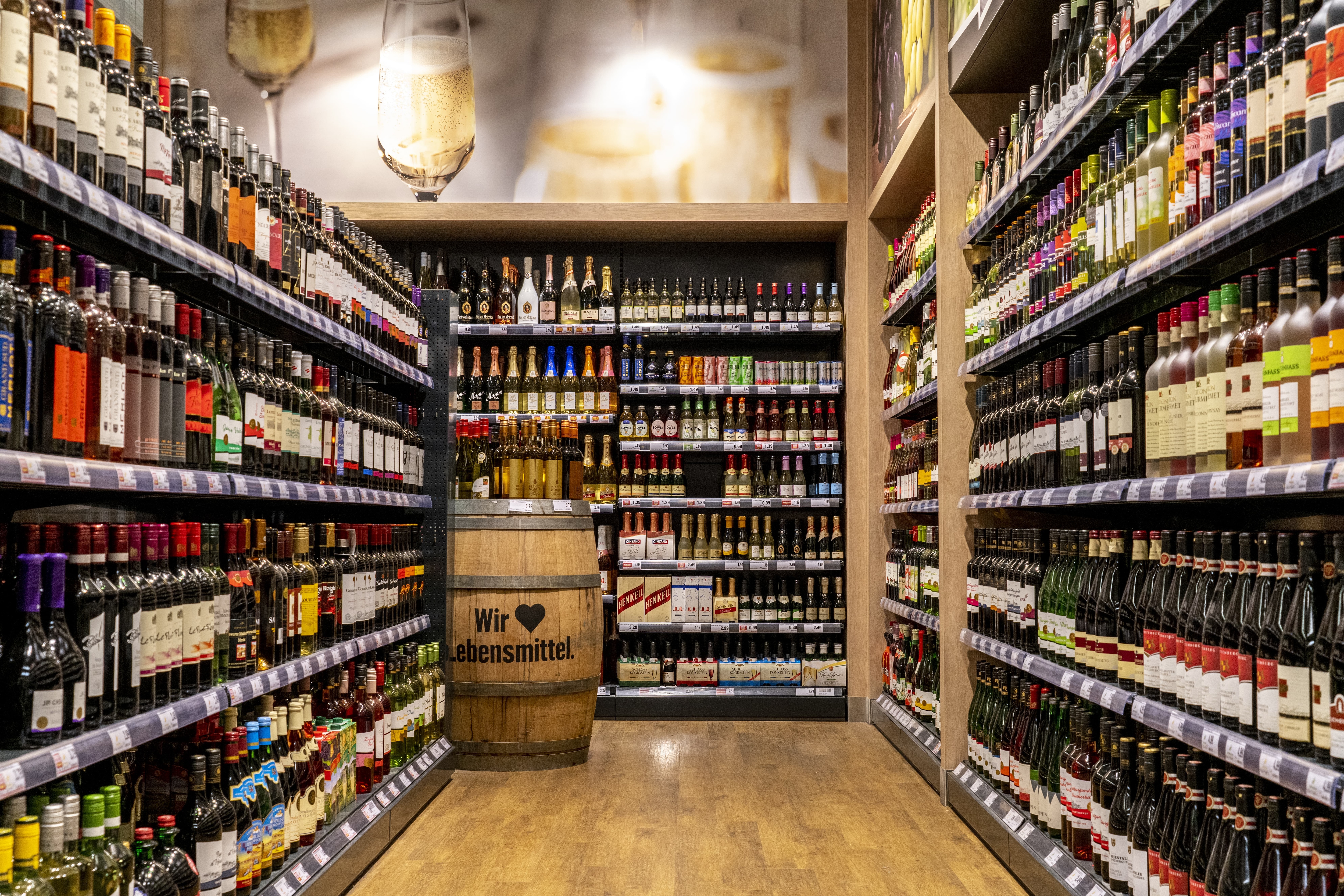Ein Gang mit Wein zu beiden Seiten in der Alkoholabteilung eines EDEKA-Markts.