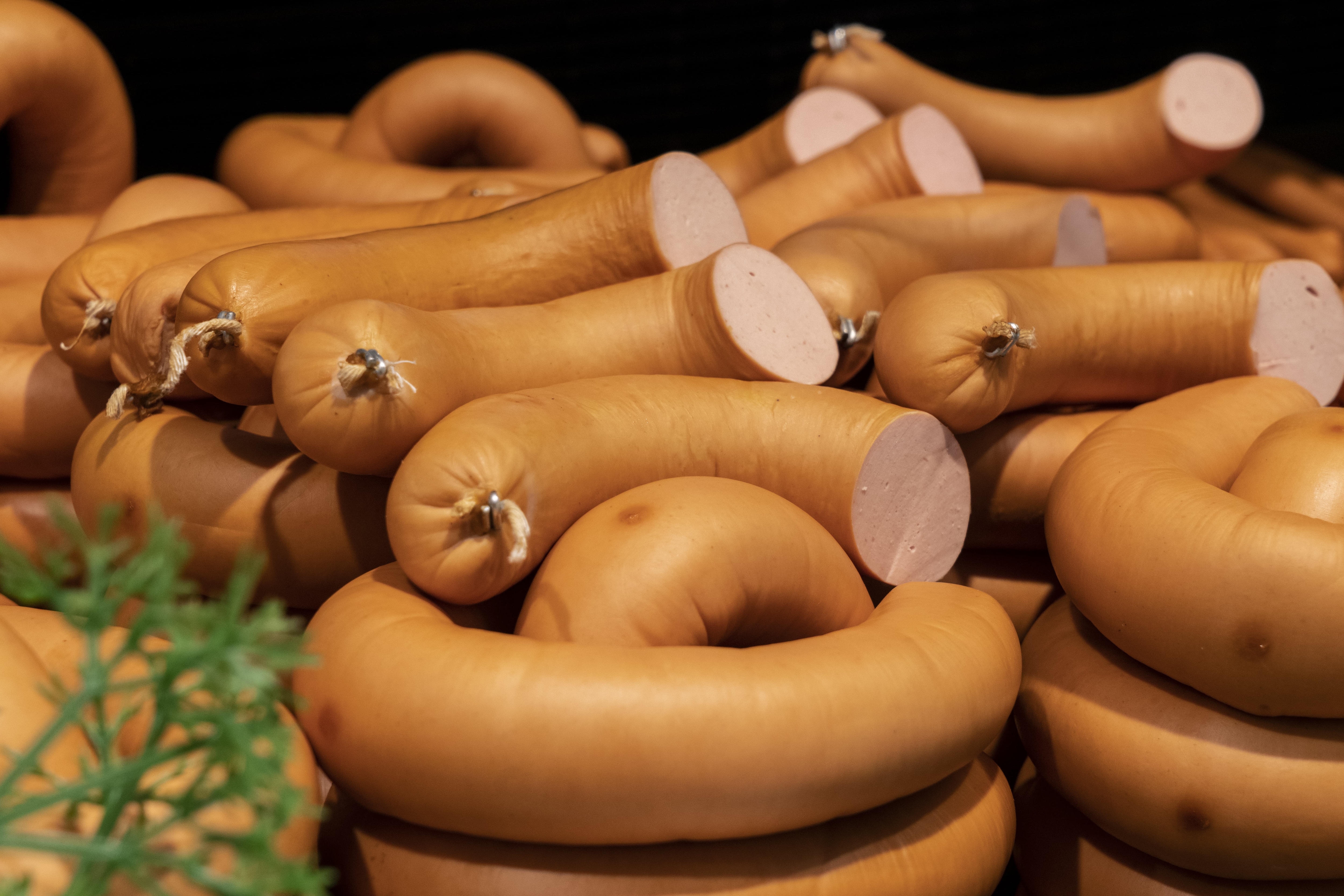 Wurstauslage in der Nahaufnahme, vorn grüne Deko.