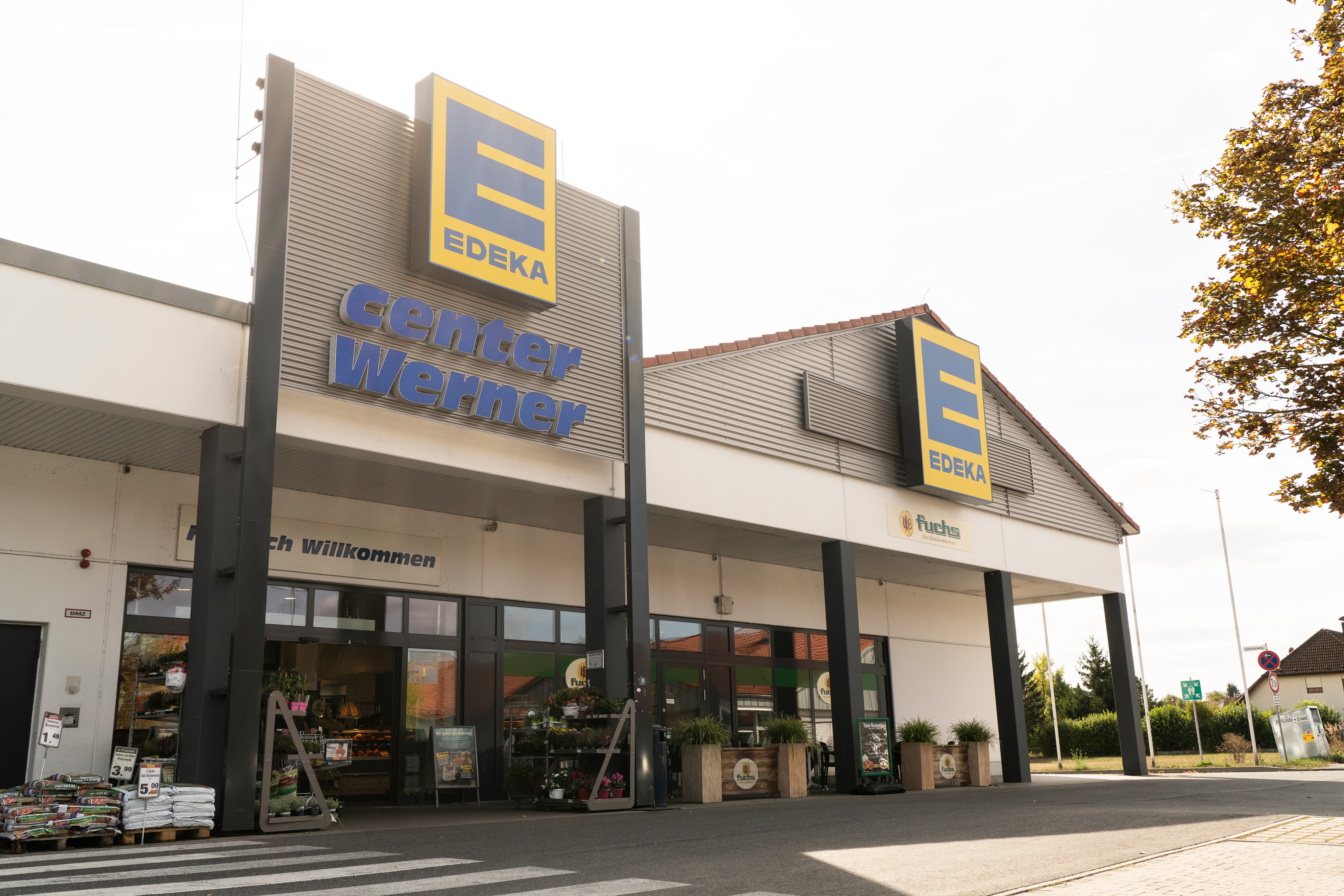 Front des Markts, sonnenbeschienen, mit dem Schriftzug EDEKA center über dem Eingang.