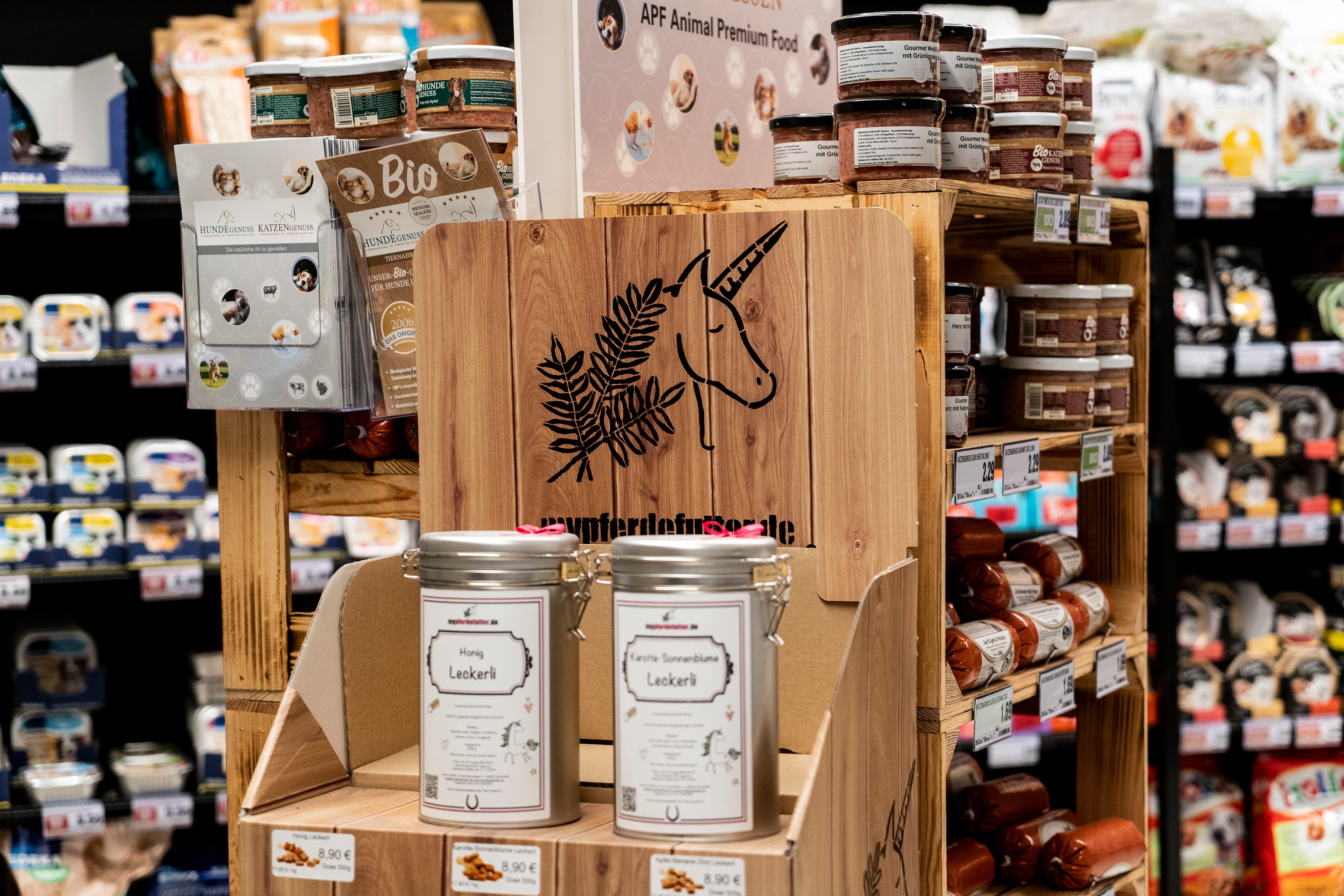 Bunt gefüllte Regale in einem EDEKA-Markt, im Vordergrund Tierleckerlies.