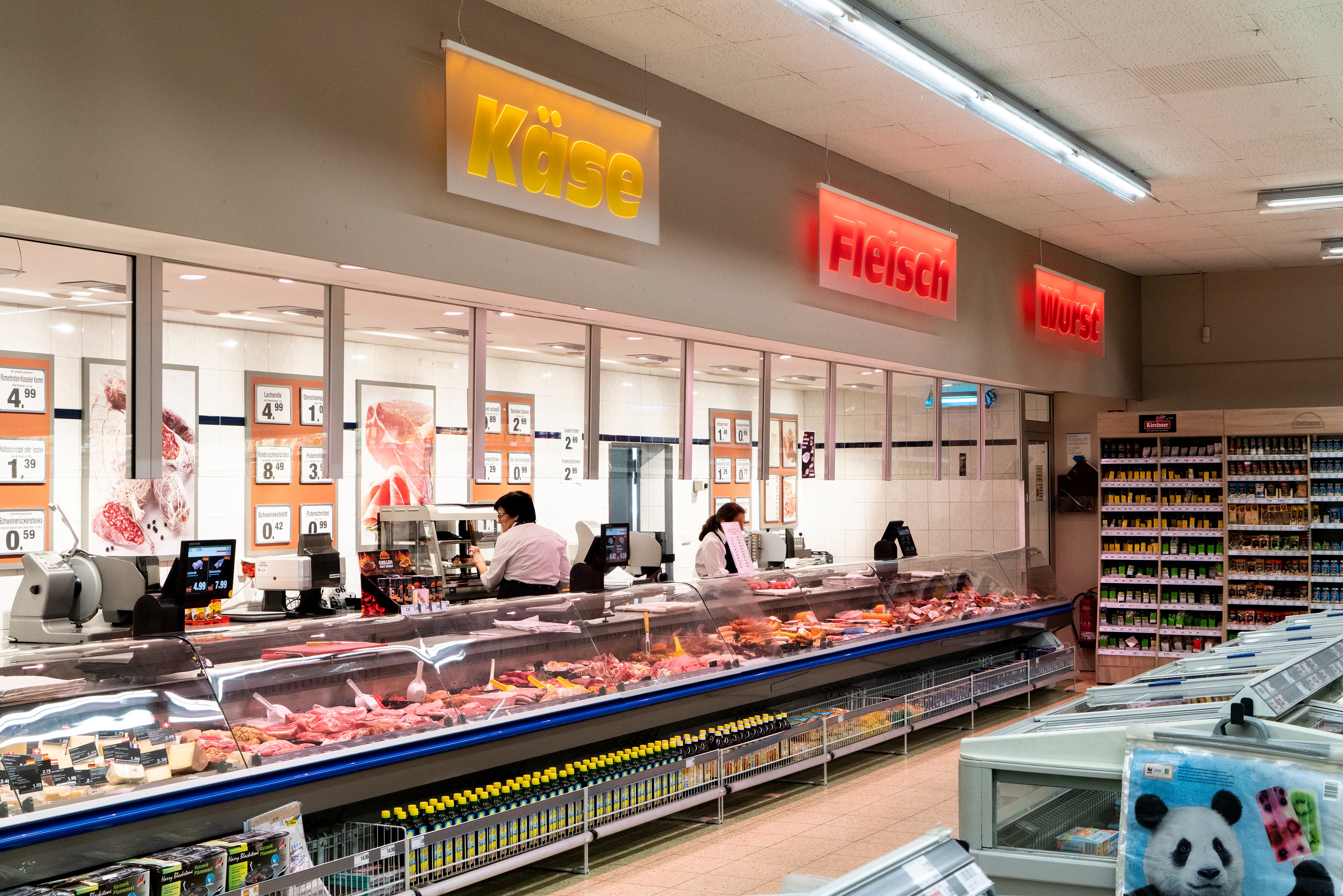 Die Bedientheke eines EDEKA-Markts, mit Kacheln am Boden und den Neonlettern Käse – Fleisch – Wurst darüber.