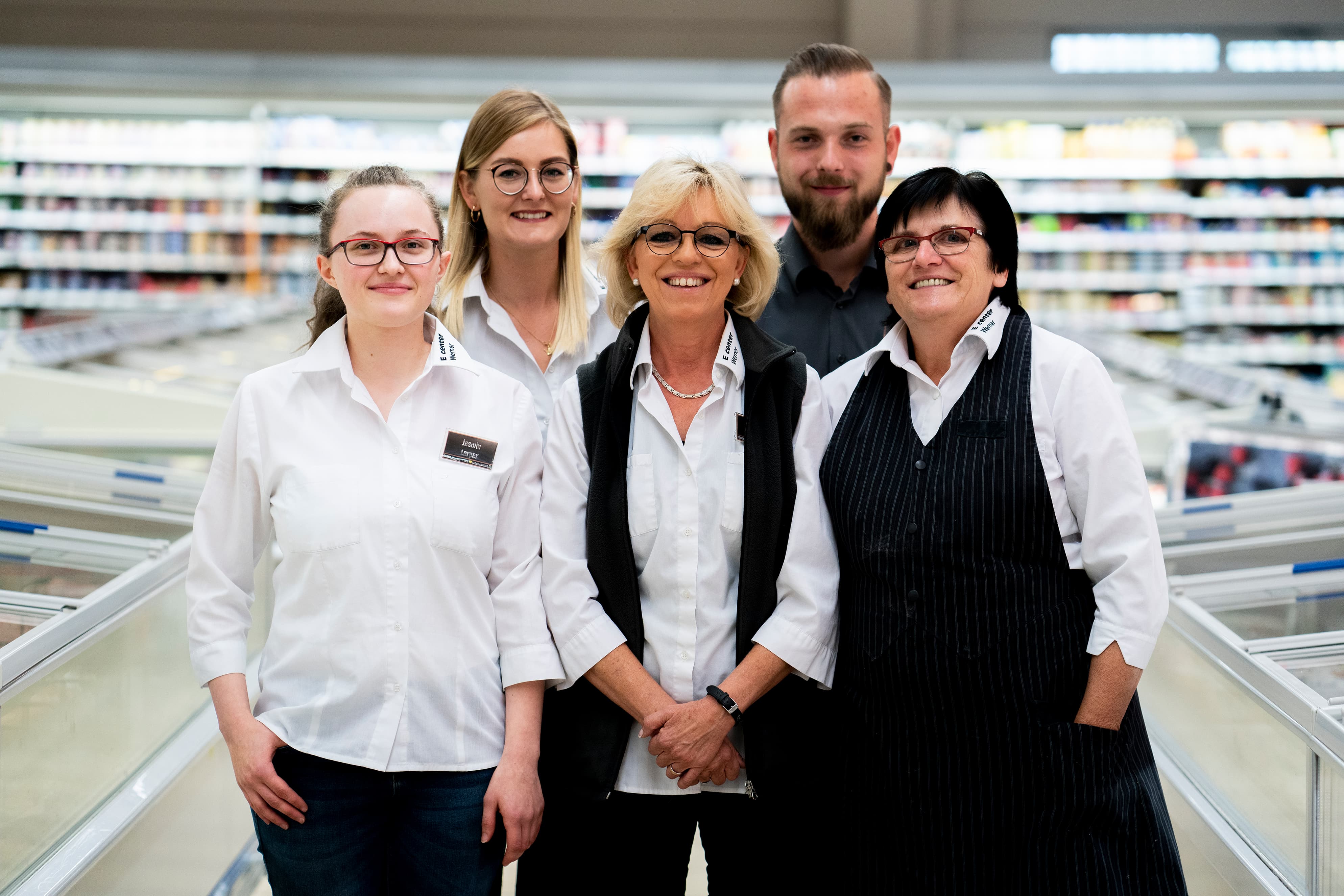 Gruppenfoto des Teams dieses EDEKA-Markts, aufgenommen im Gang im Tiefkühlbereich.