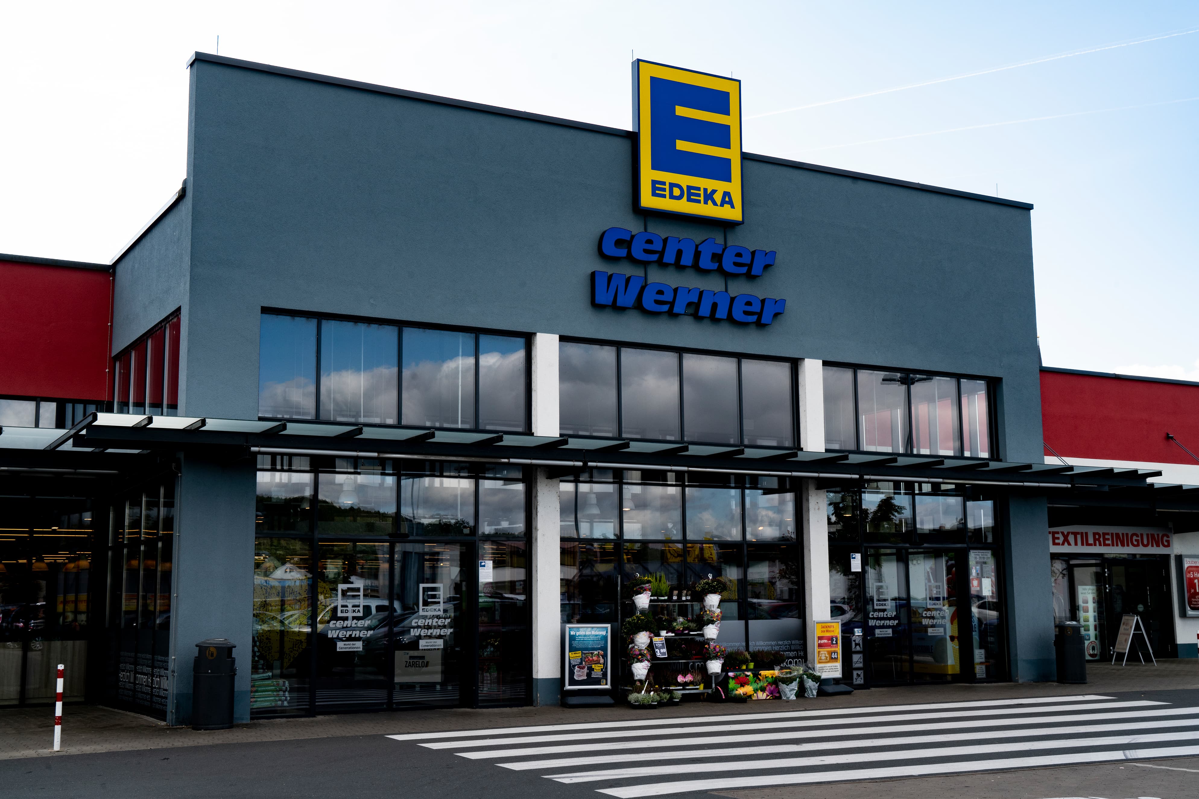 Front des Markts, sonnenbeschienen, mit dem Schriftzug EDEKA center über dem Eingang.