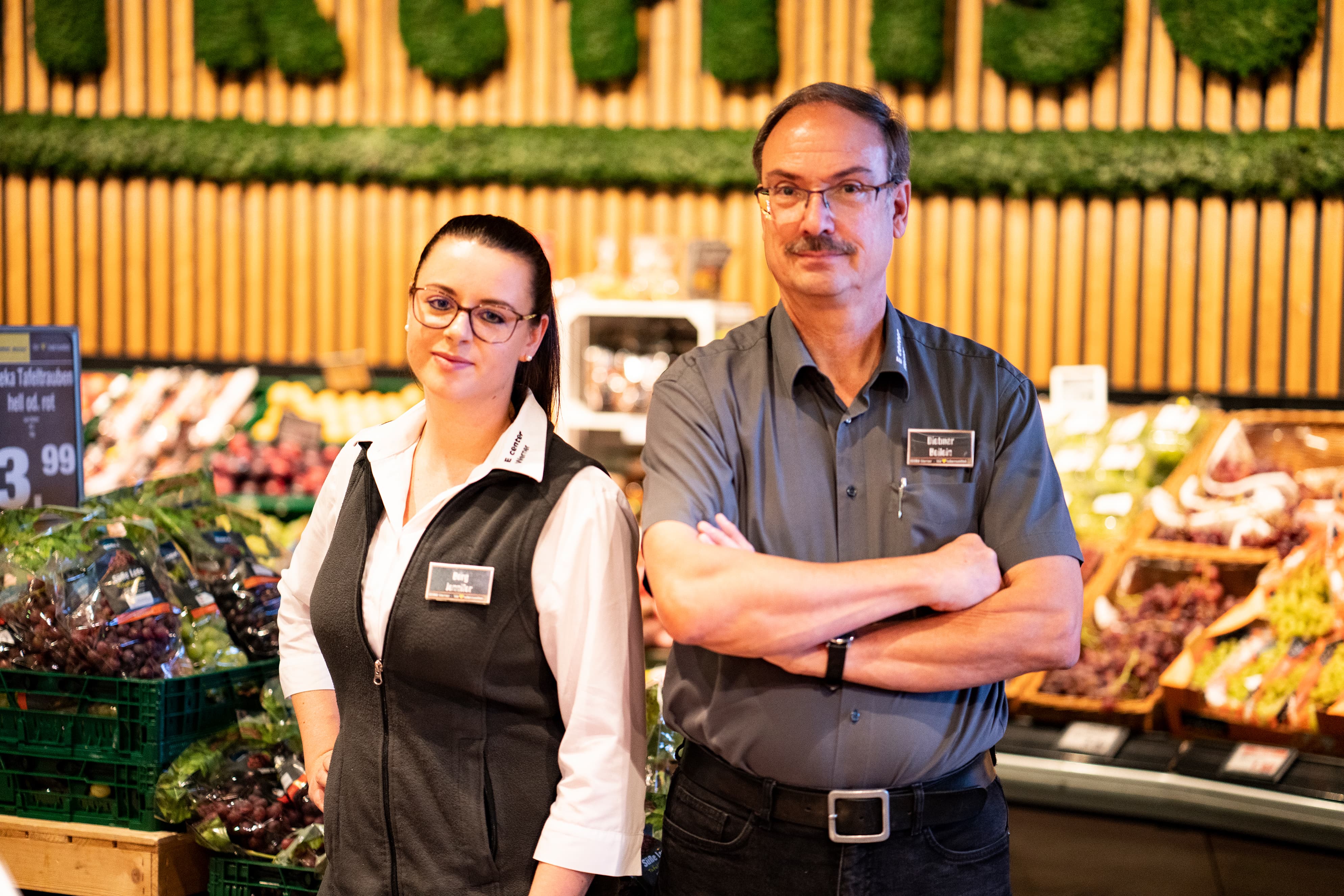 Eine junge Frau und ein älterer Mann stehen in der Obst- und Gemüseabteilung eines EDEKA-Markts.