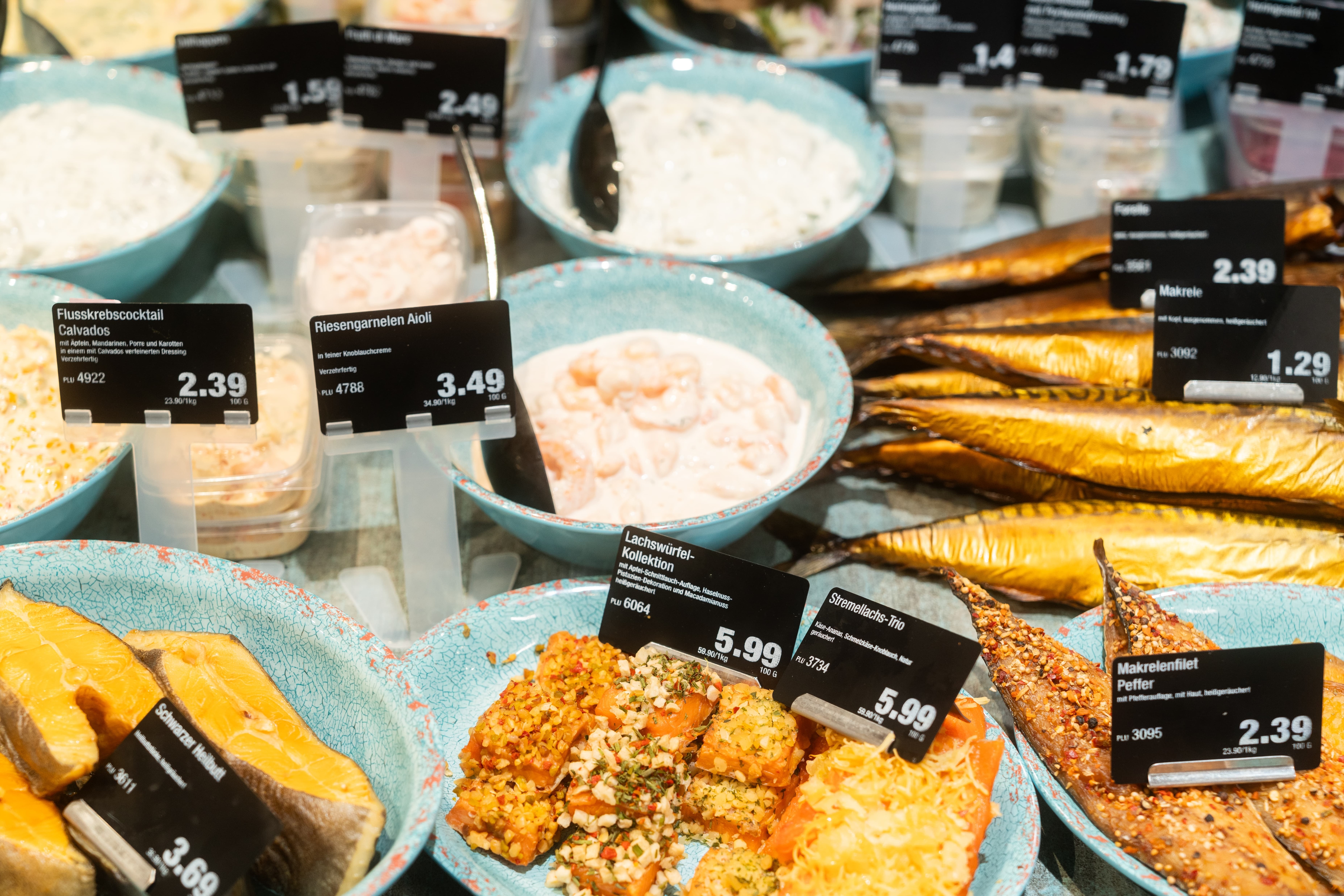 Räucherfisch und Riesengarnelen in Aioli mit Preisschildern.