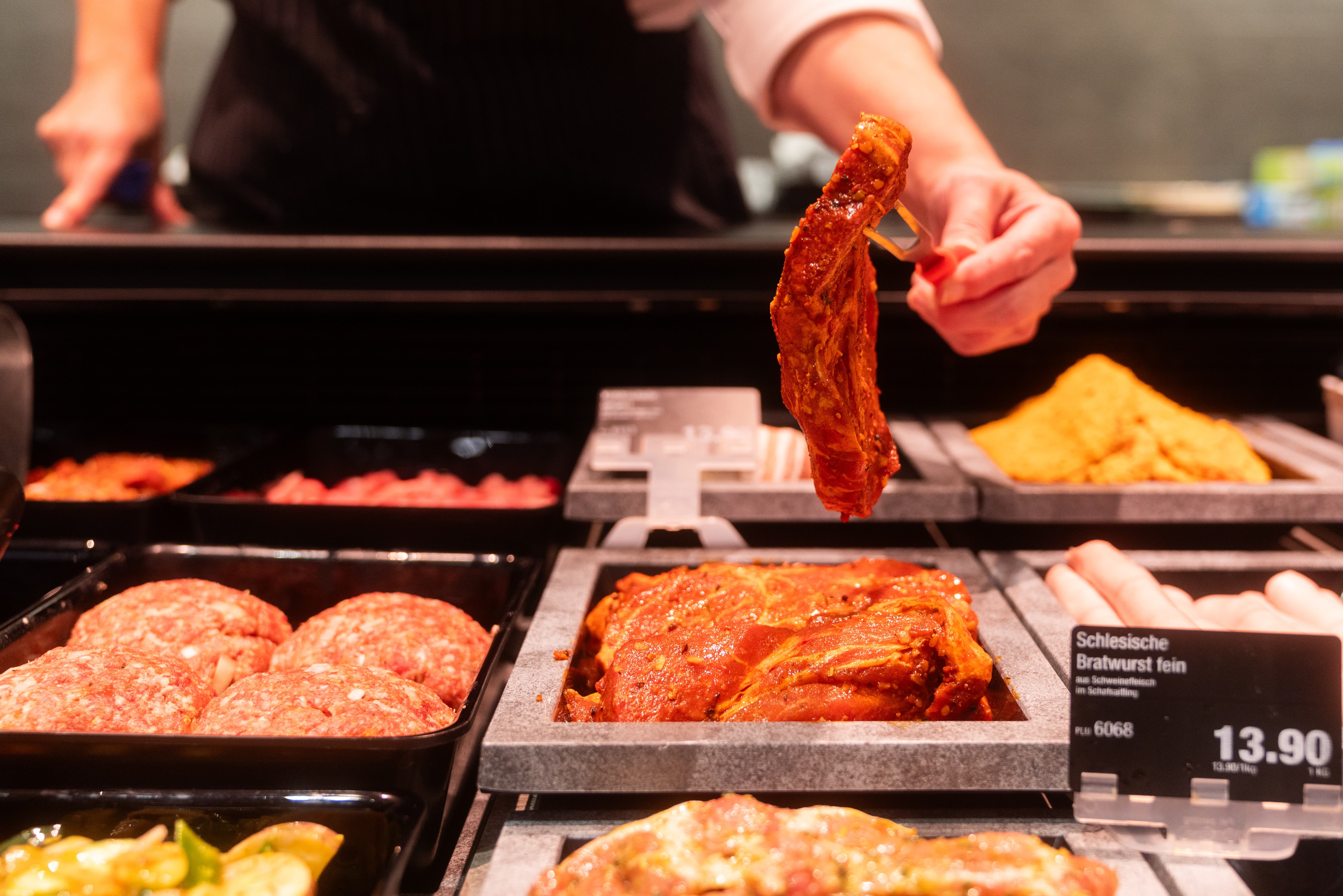 Jemand hält ein Stück mariniertes Fleisch mit einer Gabel hoch.