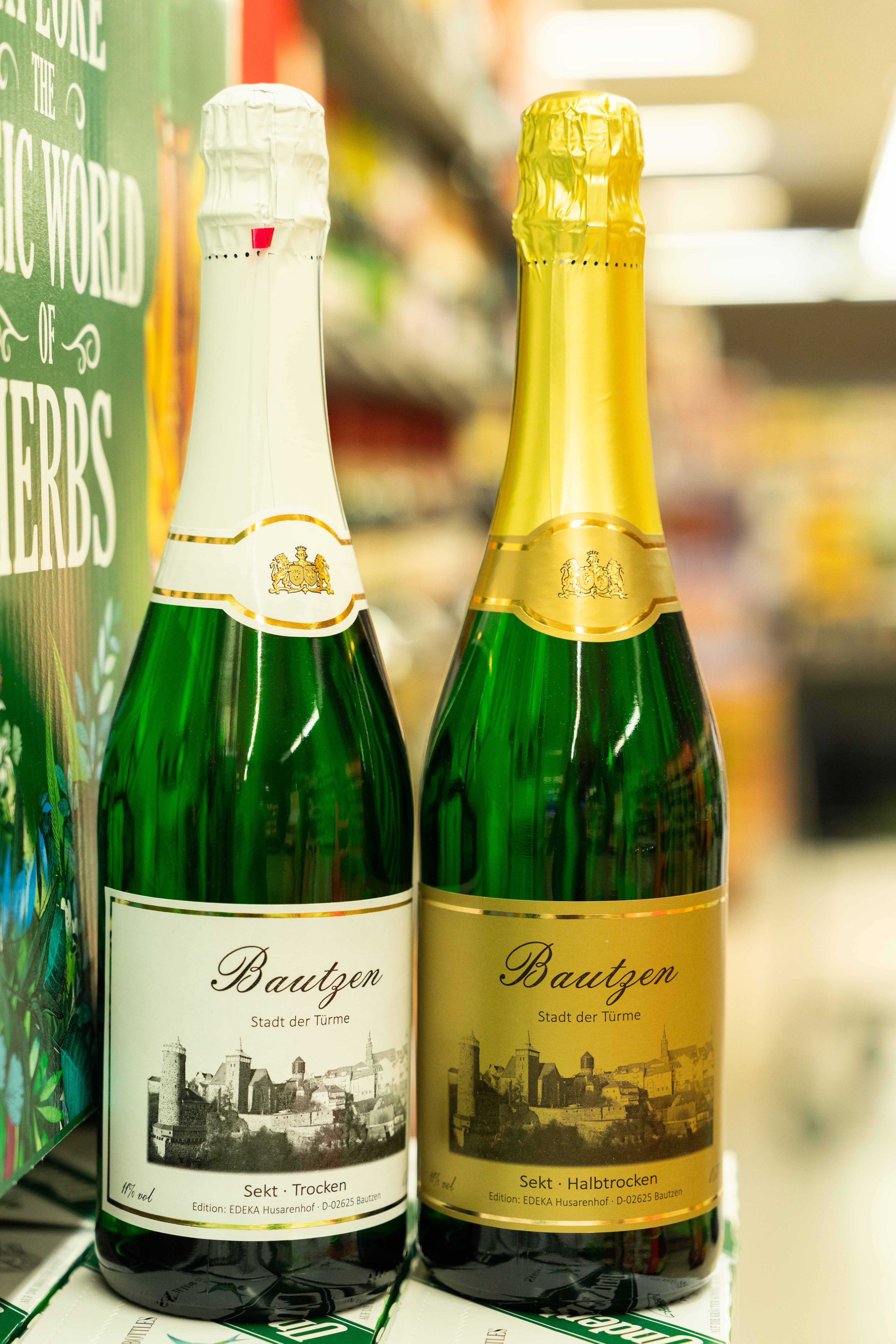 Zwei Sektflaschen mit einem Etikett auf dem Bautzen abgebildet ist.
