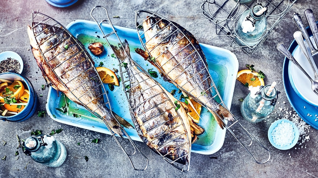 Drei gegrillte Fische in einer Auflaufform.