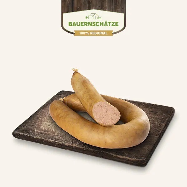 Ein Leberwurstring sowie eine aufgeschnittene Hälfte auf einem dunklen Holzbrett.