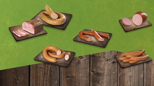 Verschiedene Wurstwaren von Bauernschätze liegen jeweils auf einem Brett.