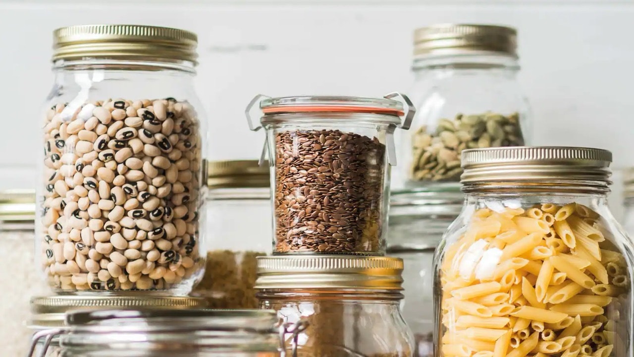 Durchsichtige Vorratsgläser mit Nüssen, Kernen und Nudeln.