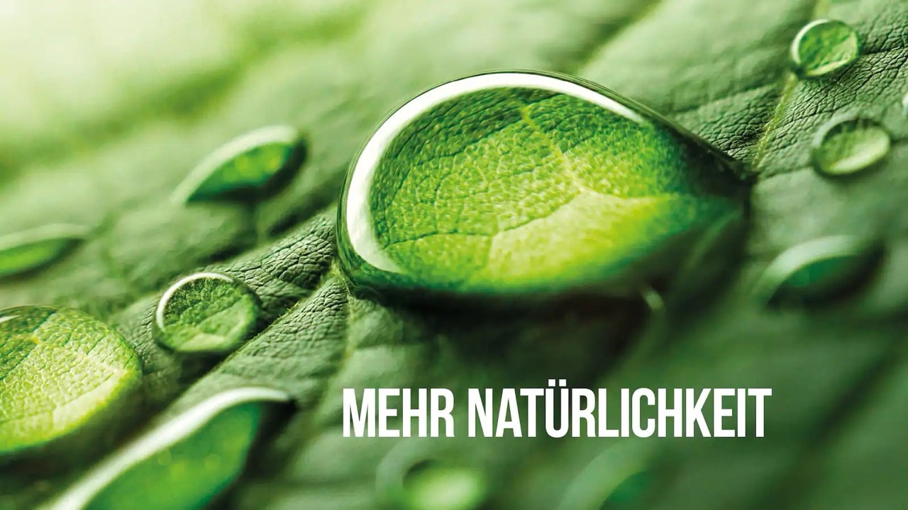 Nahaufnahme eines Wassertropfens auf einem grünen Blatt. Text: Mehr Natürlichkeit.