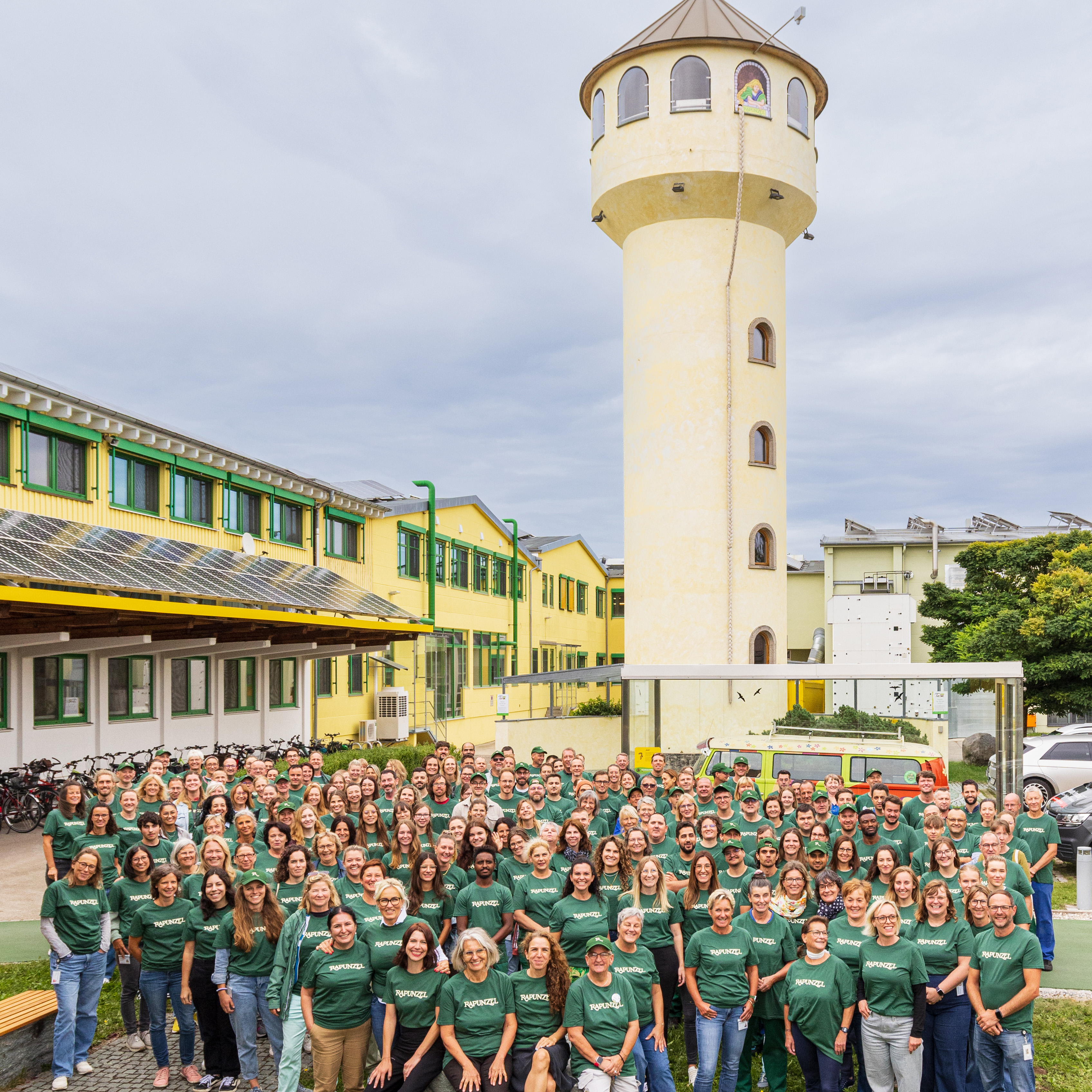 Das gesamte Team von Rapunzel in Mitarbeitershirts steht vor der Produktionsstätte.