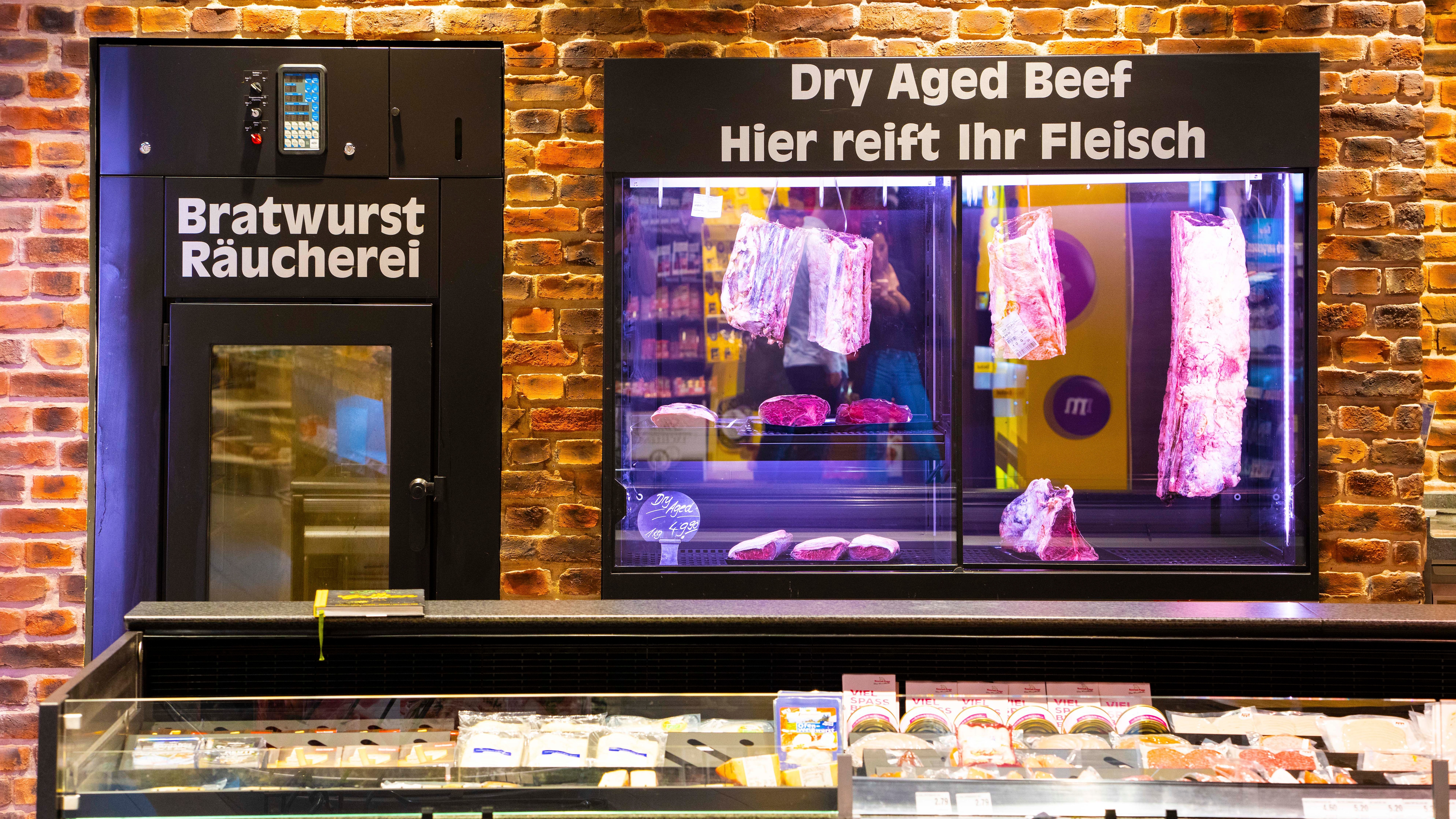 Zwei beleuchtete Schränke: Bratwurst Räucherei und Dry Aged Beef Hier reift ihr Fleisch.