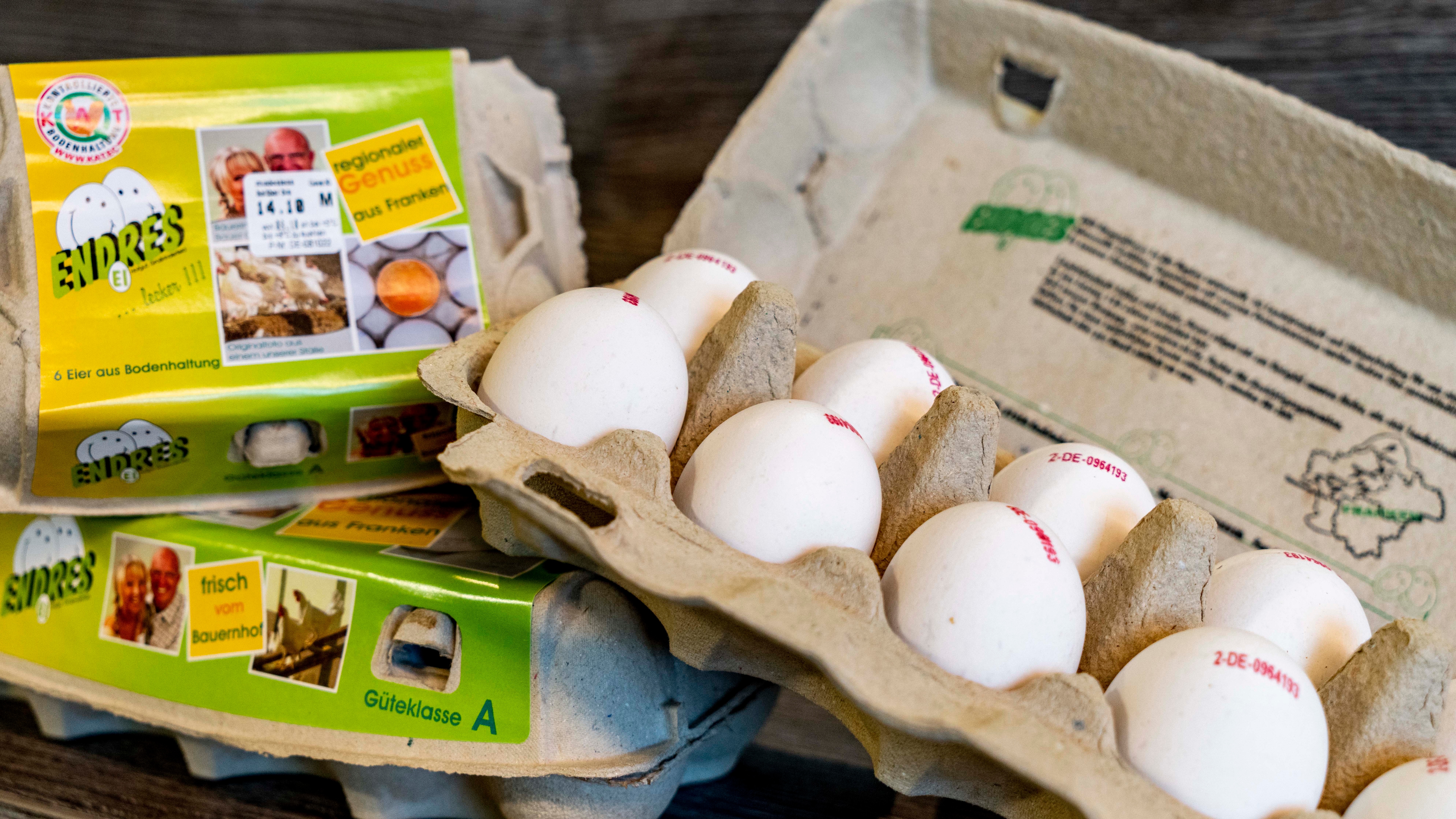 Eine offene und zwei geschlossene Eierpackungen.