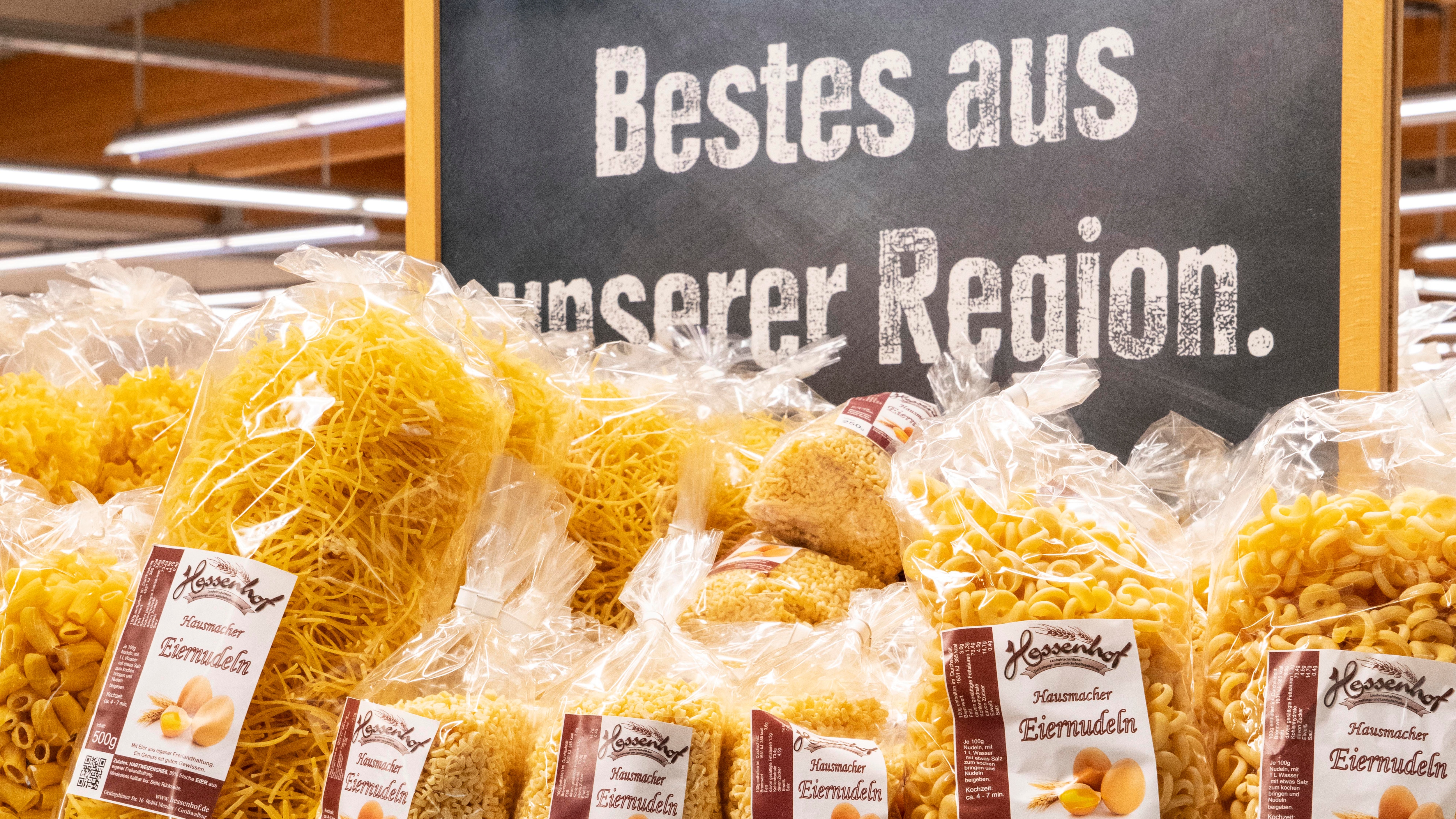 Nudelauslage im Supermarkt. Dahinter eine Tafel, auf der Bestes aus unserer Region steht.