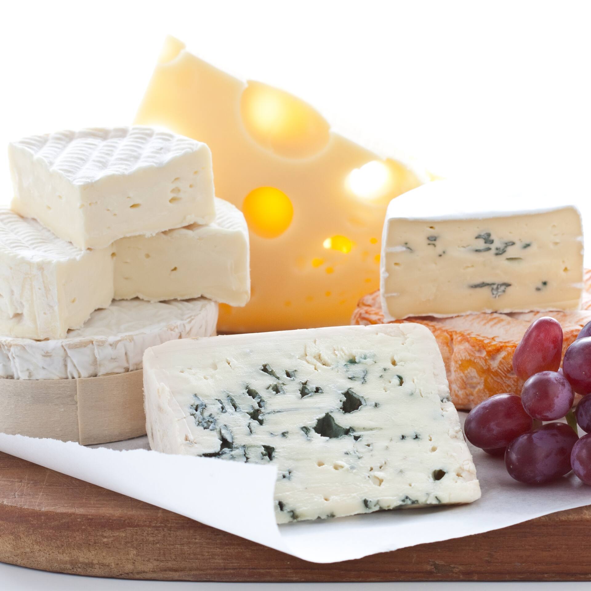 Verschiedene Käsesorten und rote Trauben.